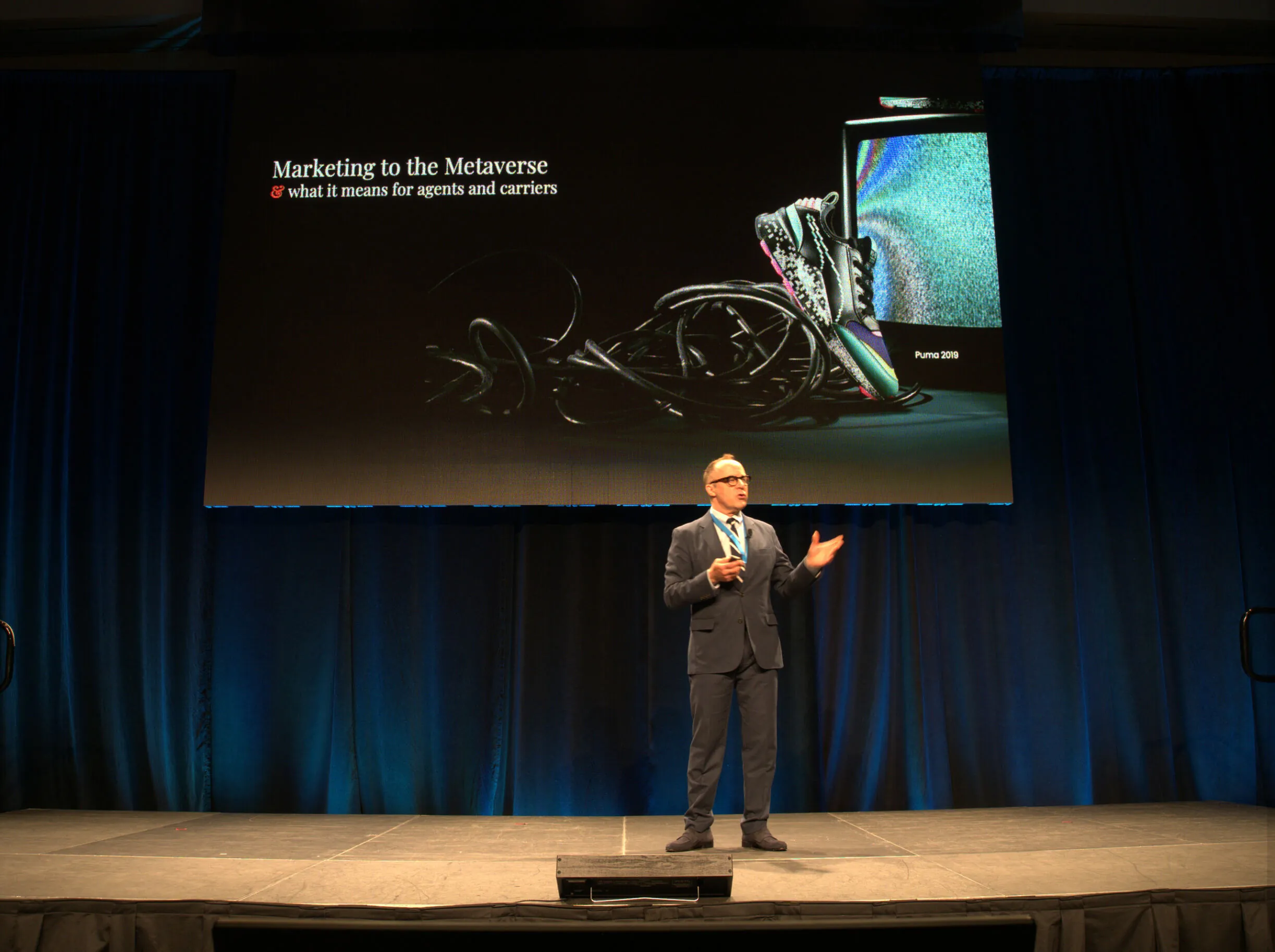 Chris C. Birt delivering a keynote beside a Marketing to the Metaverse presentation slide