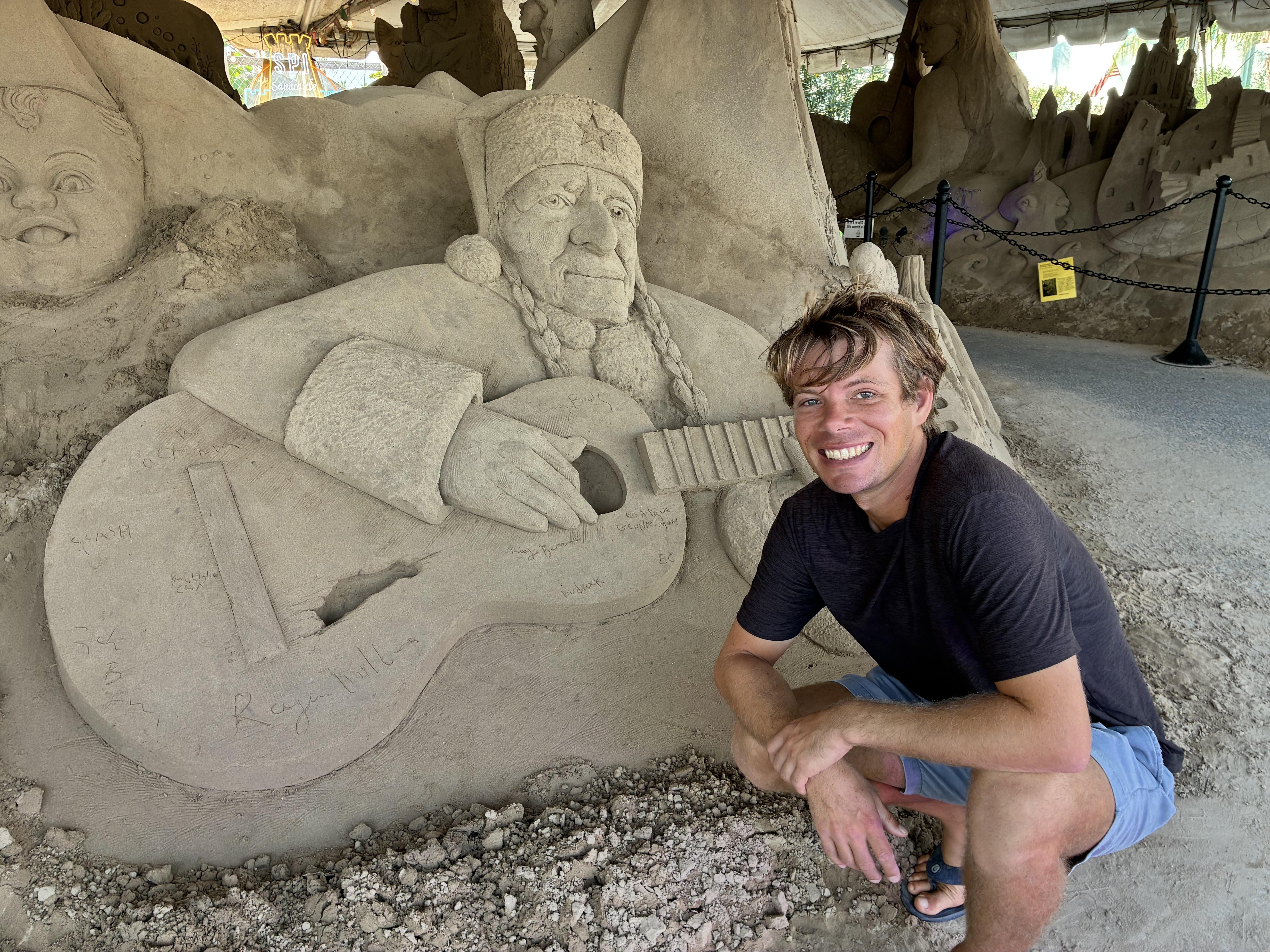 Emerson Schreiner beside Santa Willie in the holiday sculpture