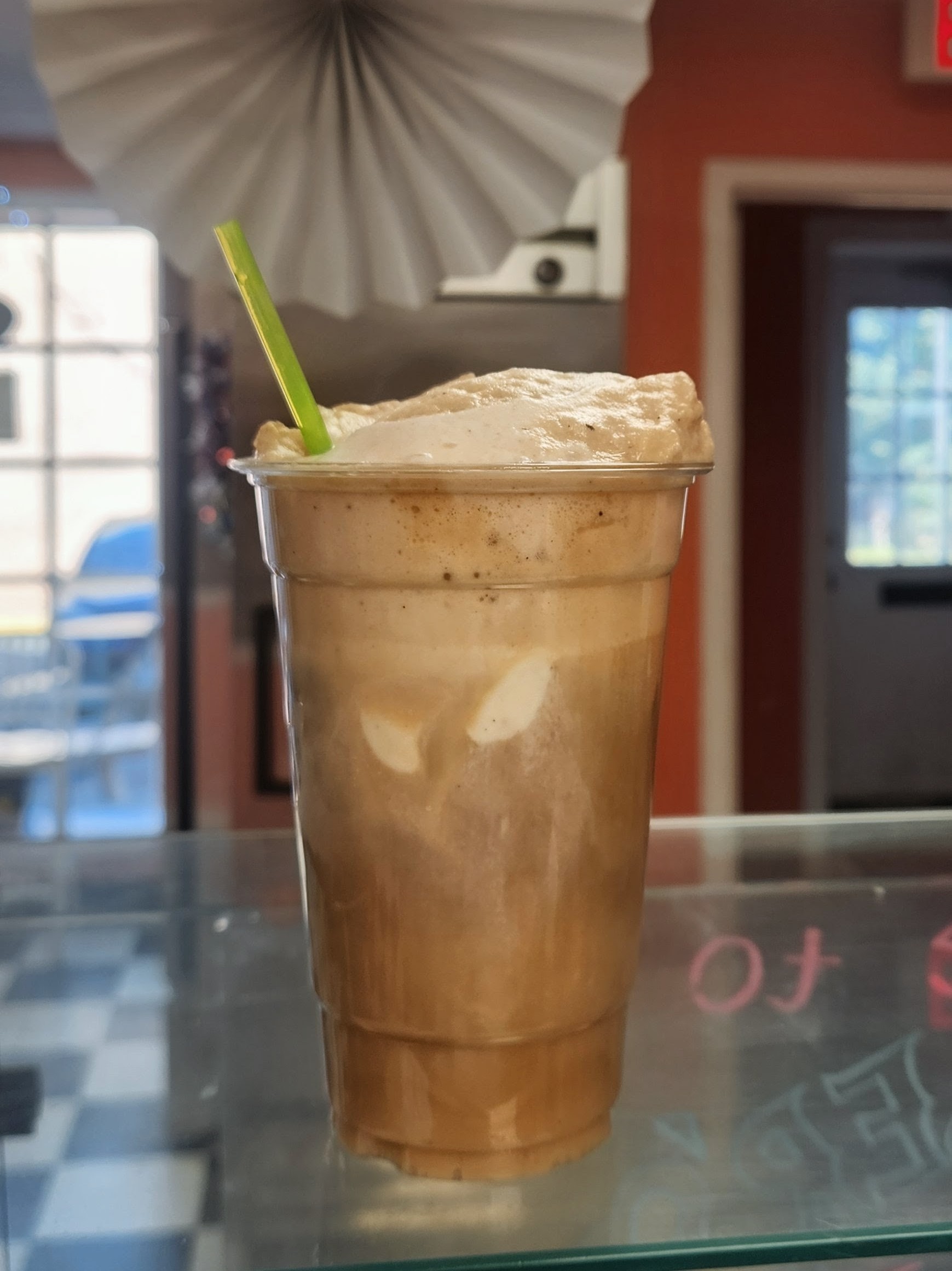 Whistler's ice cream float with a green straw at the shop counter