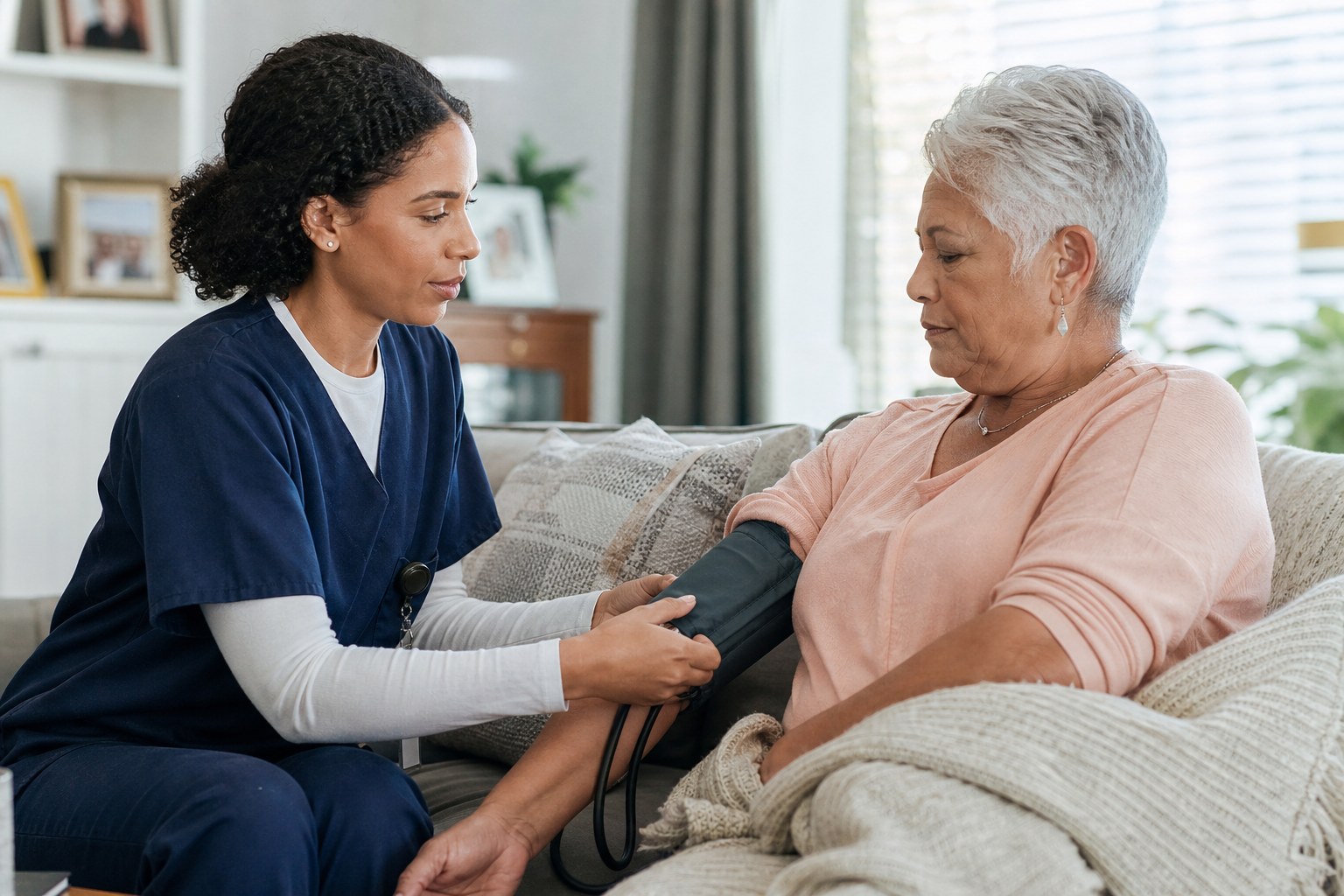 Home health nurse checking an older adult’s blood pressure at home