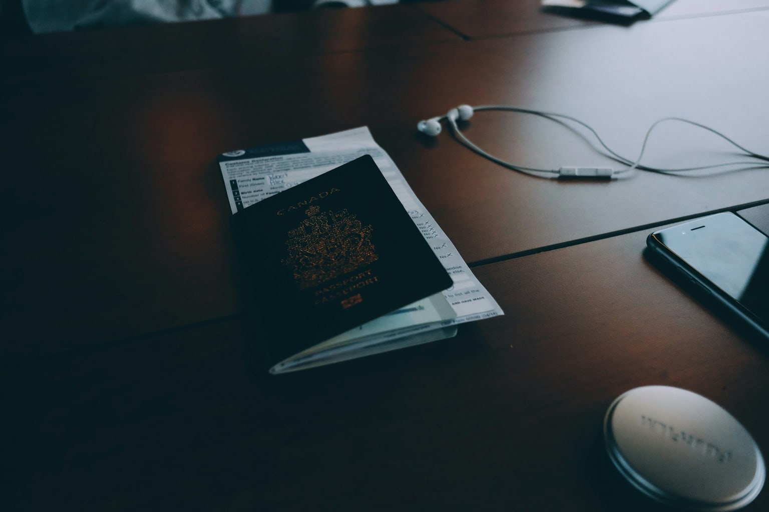 Travel documents, envelope, phone, and earphones arranged on a desk