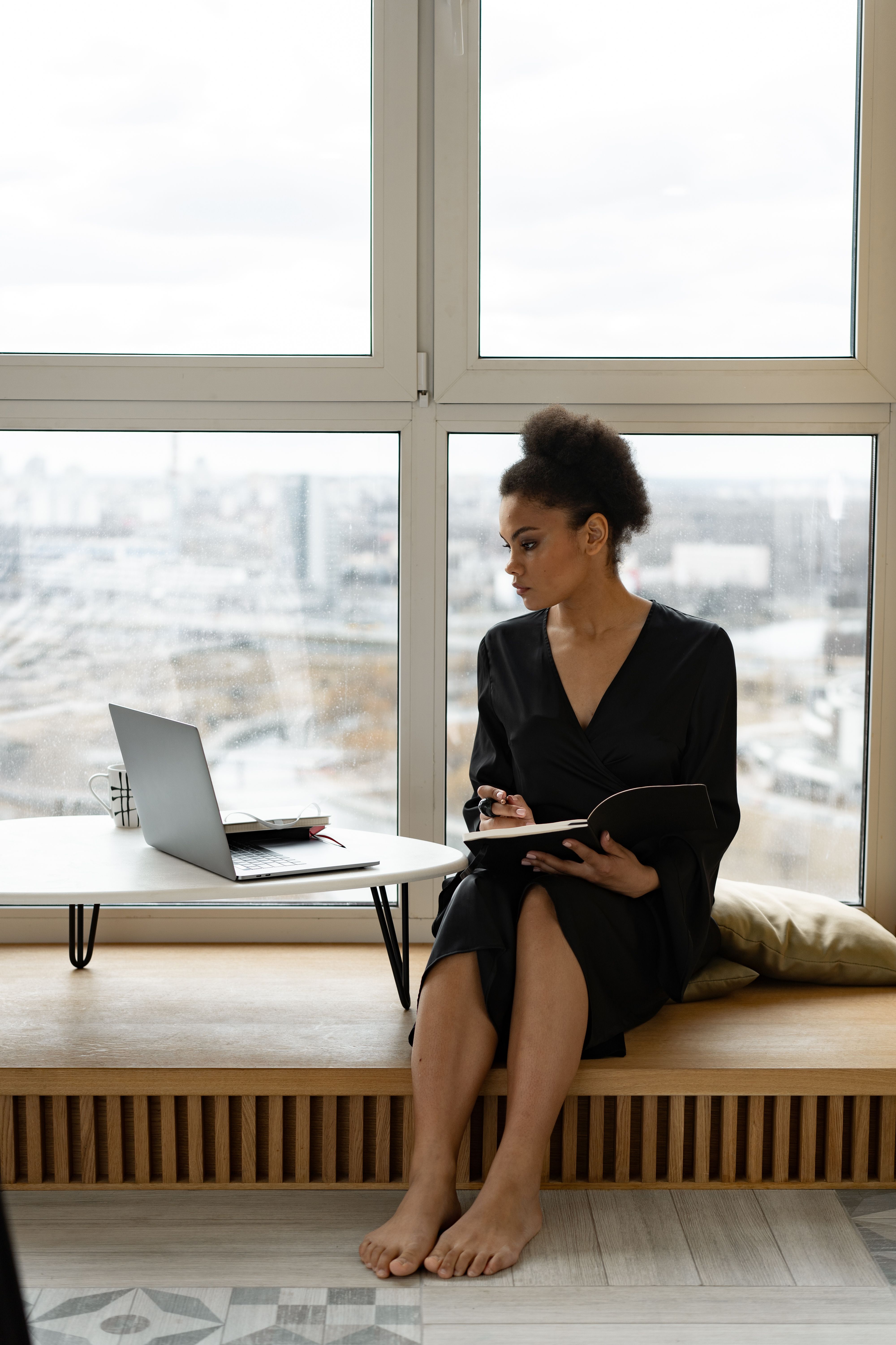 Person sitting with a notebook by a bright window