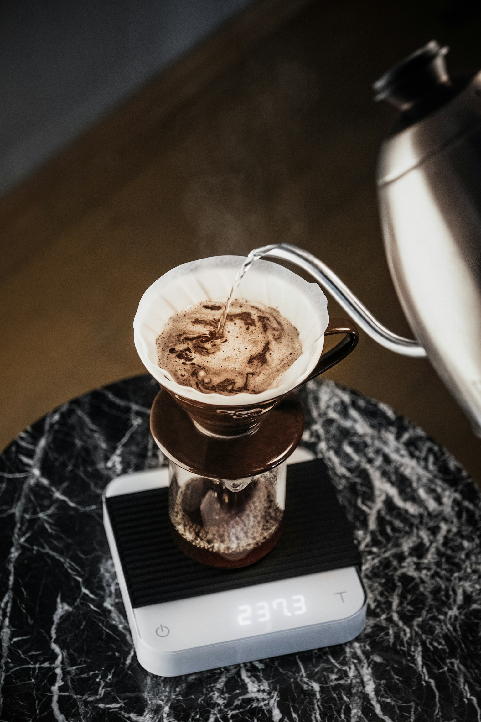 Hot water pouring over coffee in a paper-filter pour-over brewer