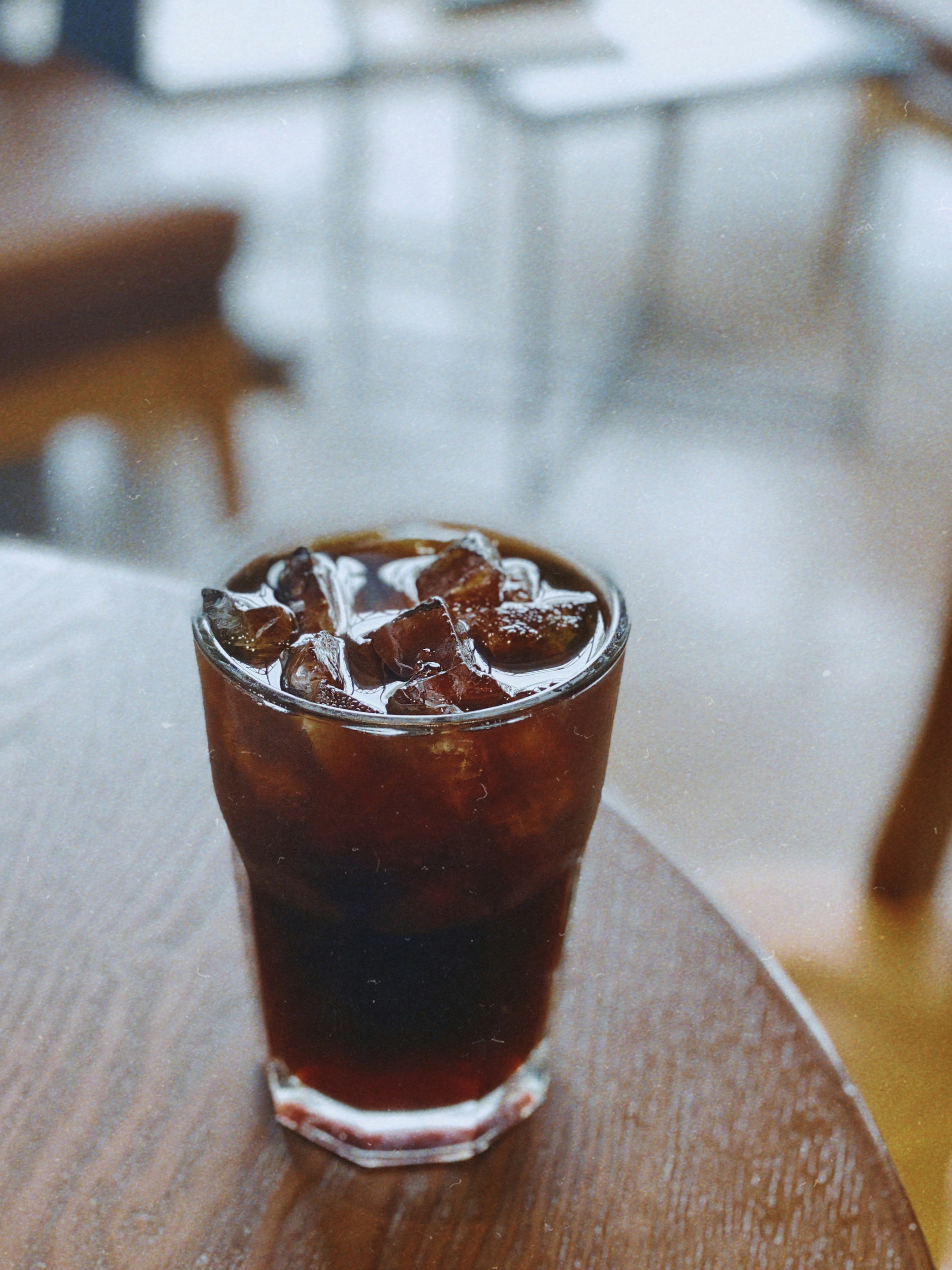 A glass of iced cold brew coffee on a wood table