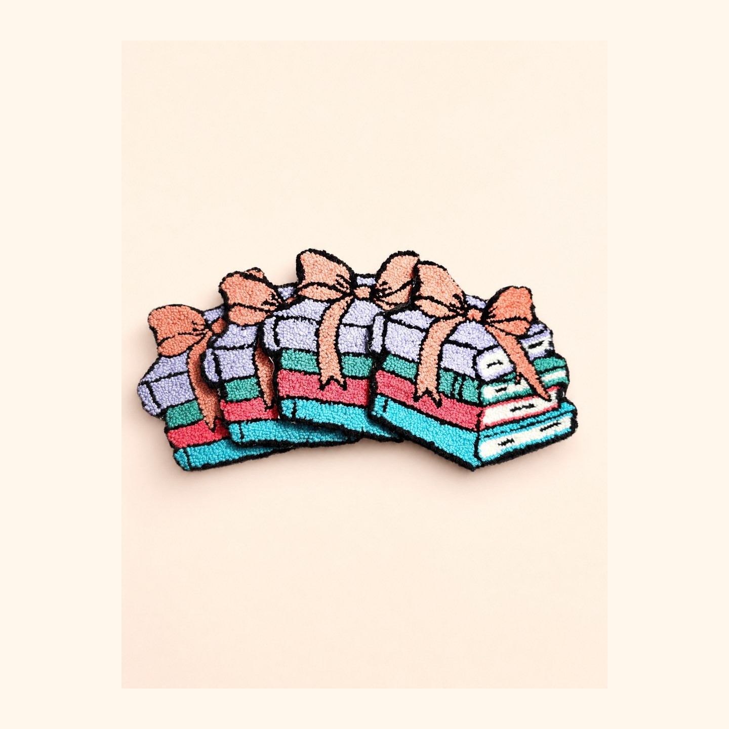 Handmade book stack punch needle coaster with a bow