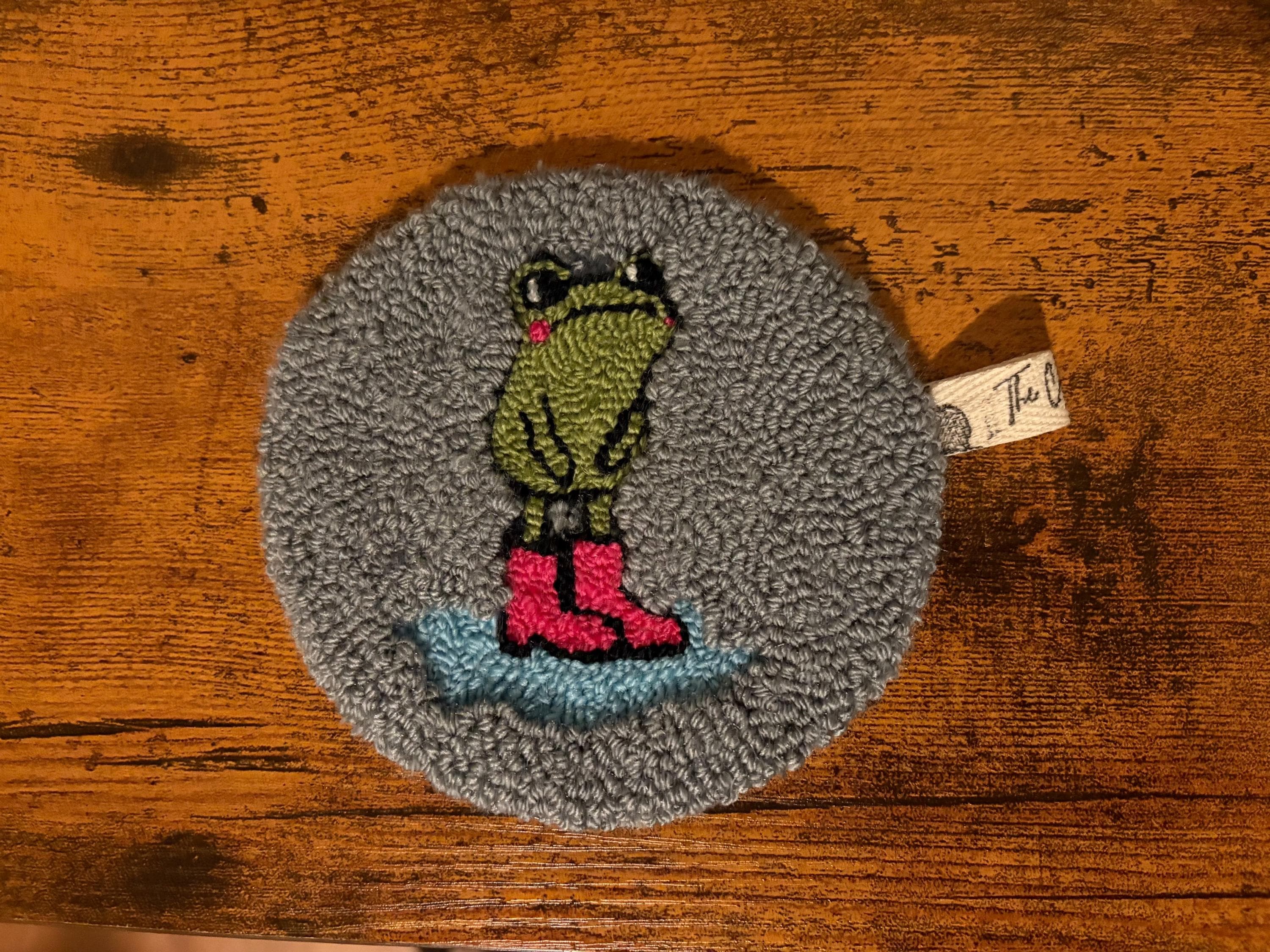 Frog in pink rain boots punch needle coaster