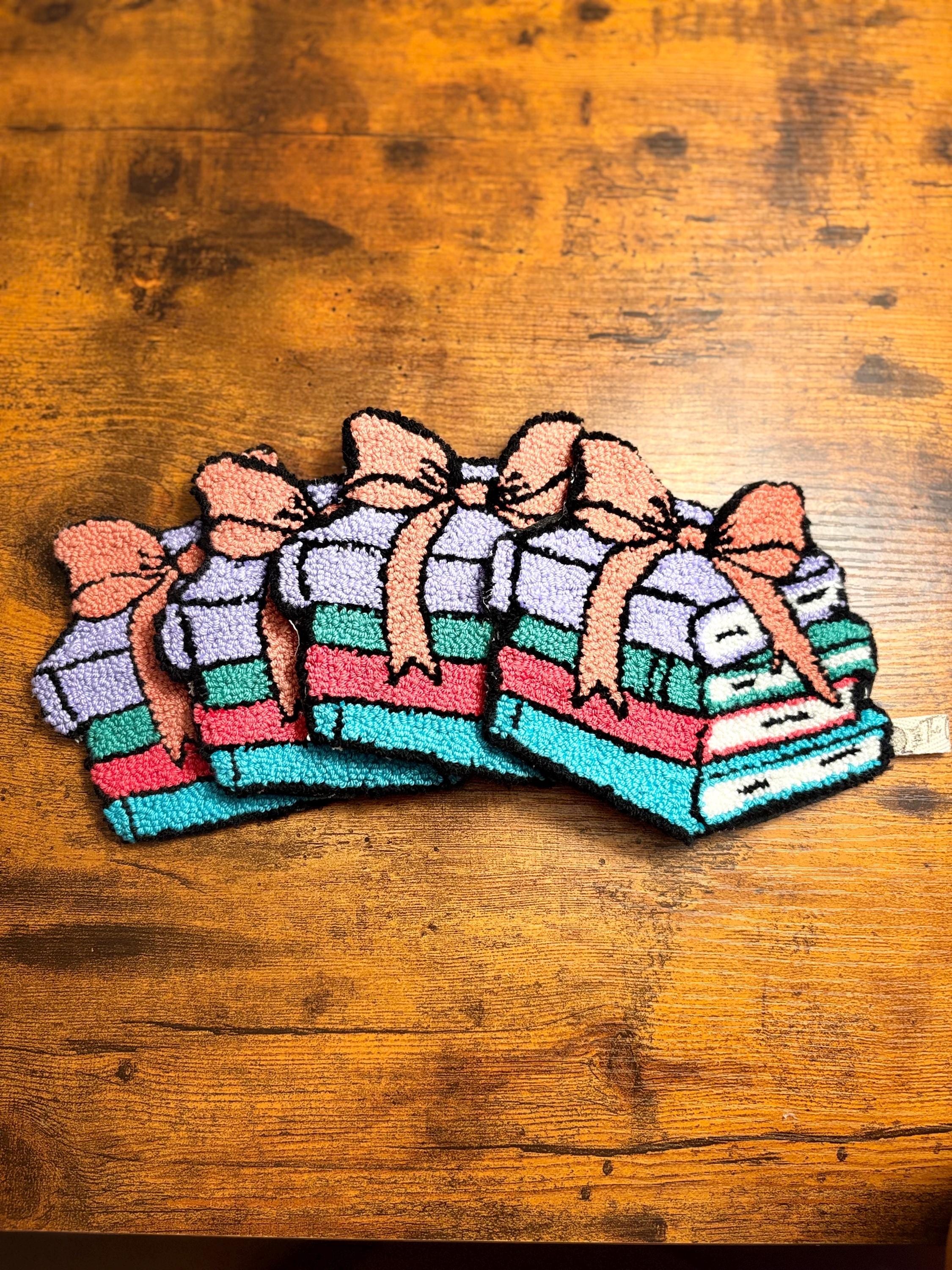 Stack of books with bow punch needle coaster