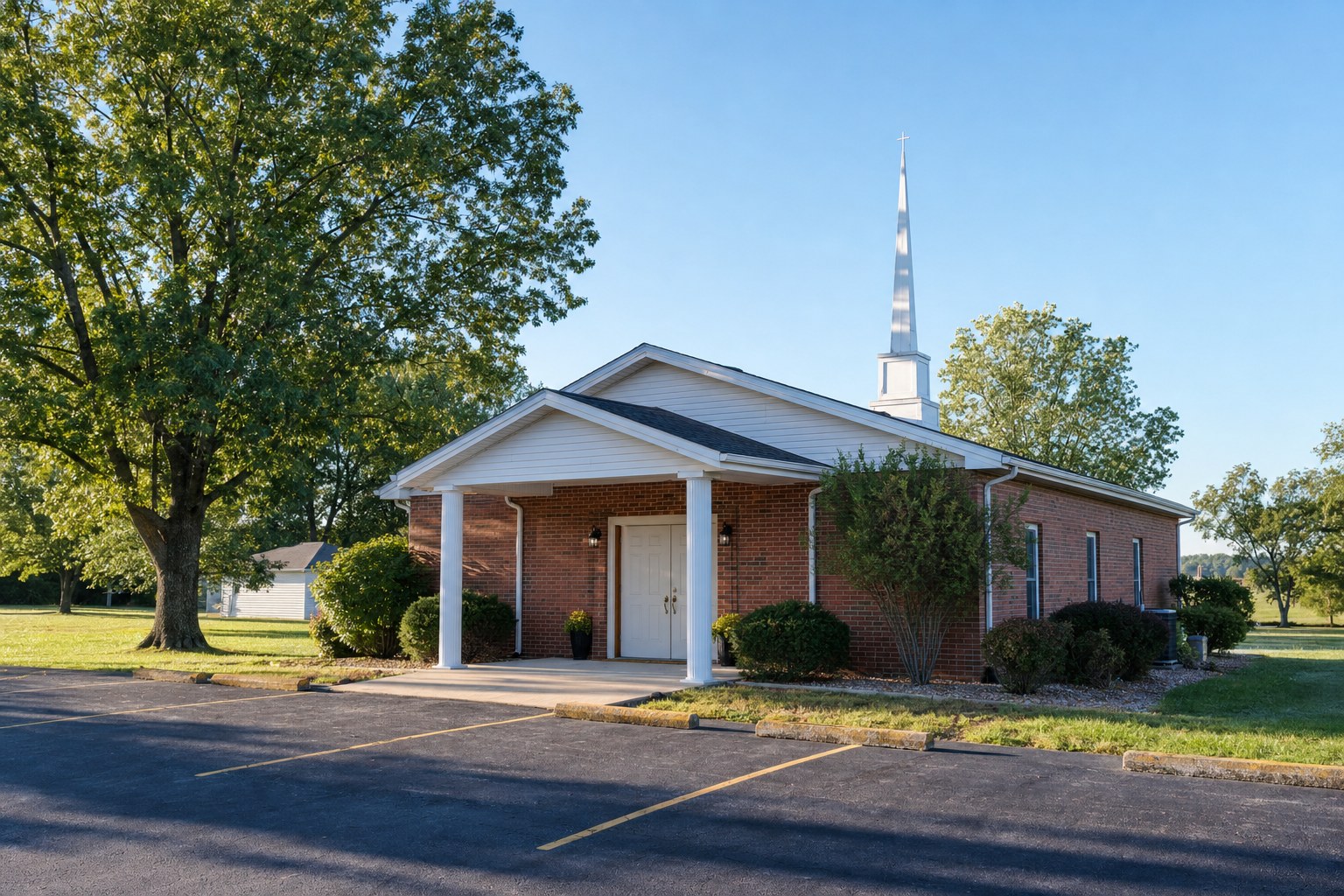A modest church entrance and parking area on a clear morning
