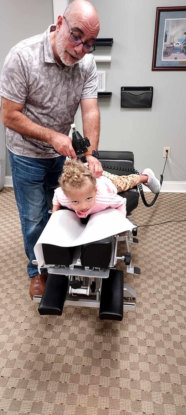 Dr. Chris providing a gentle chiropractic adjustment for a young patient