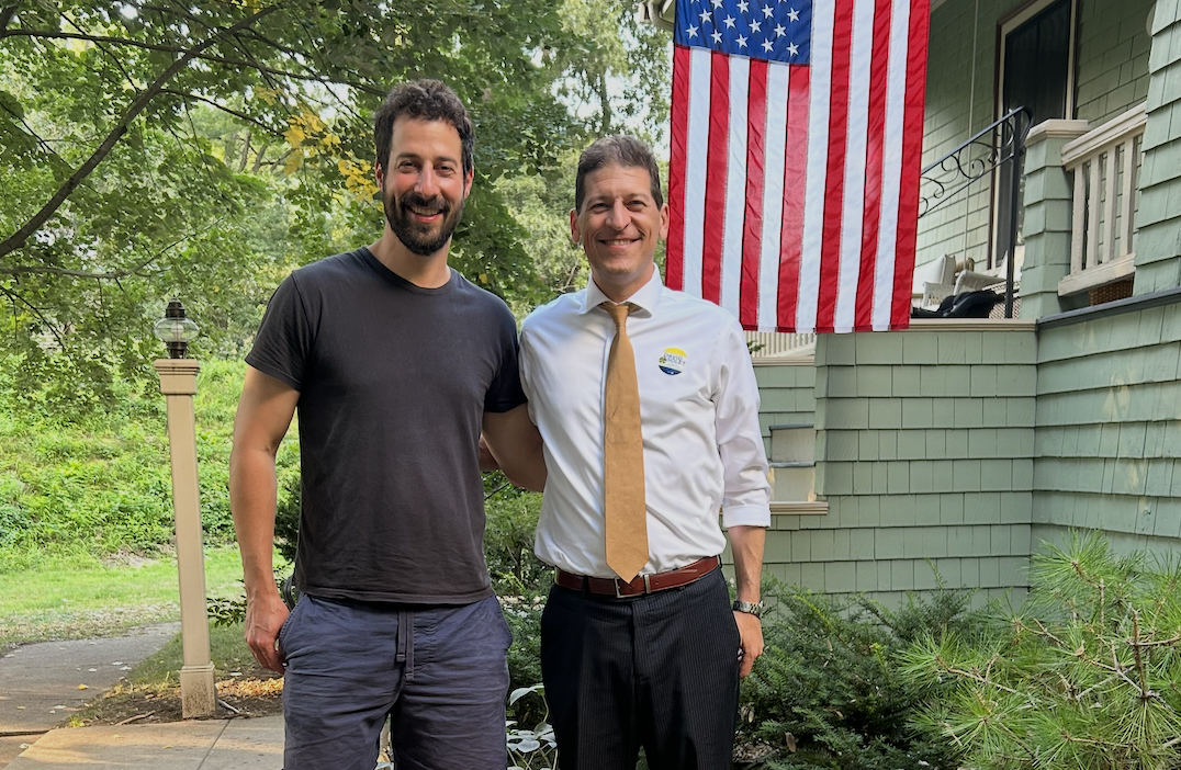 Newton City Councilor David Micley with David Solet in front of an American flag