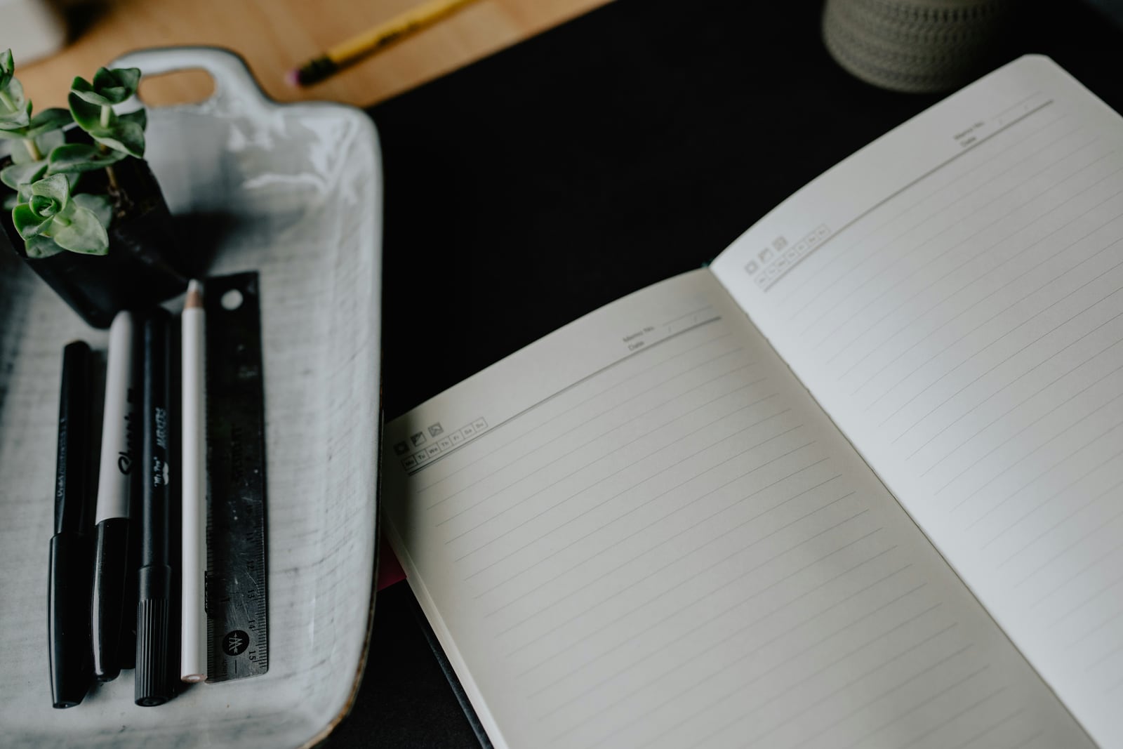Open notebook and pens on a desk