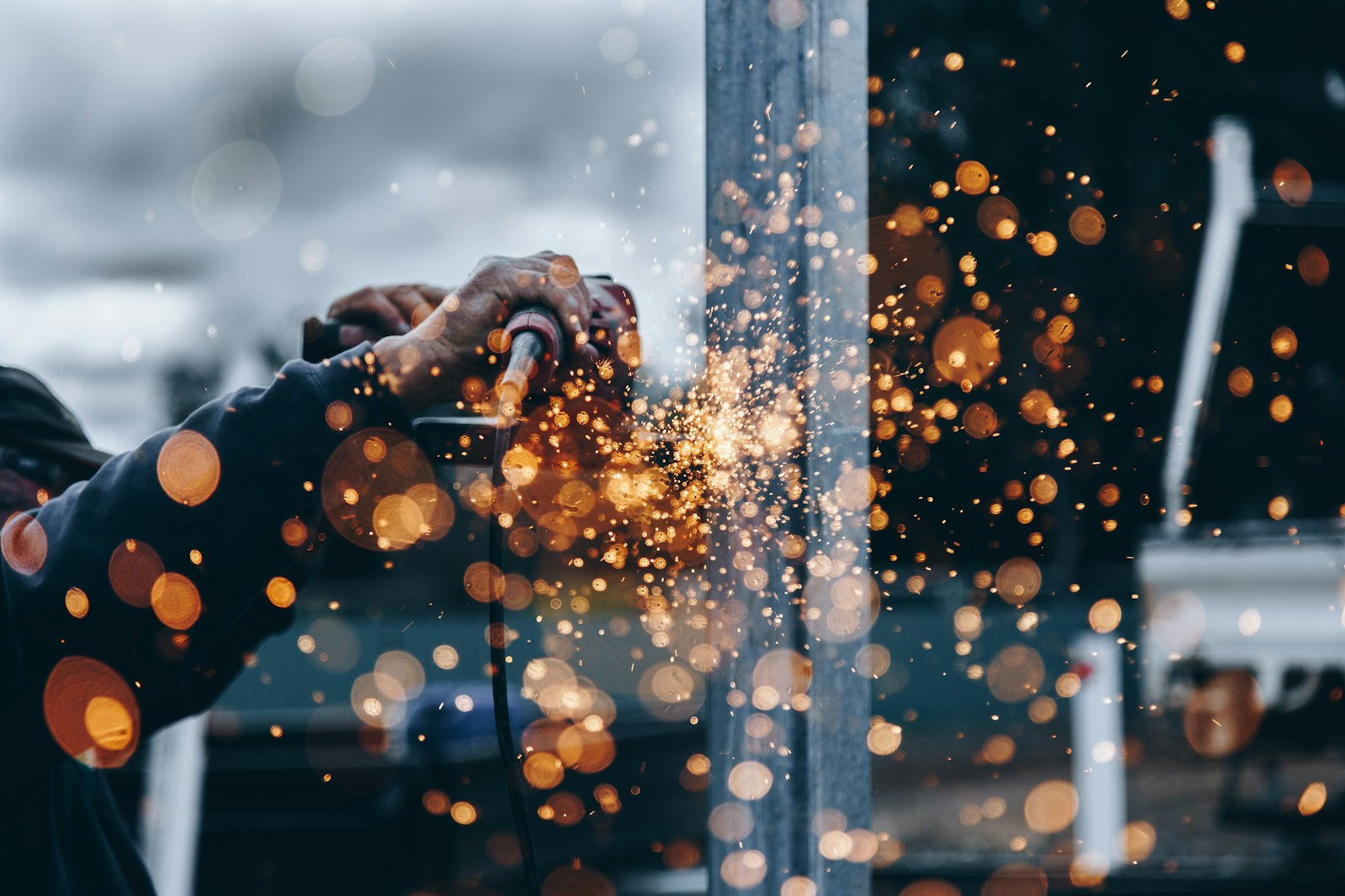 Welder working on a structural steel component in a manufacturing facility