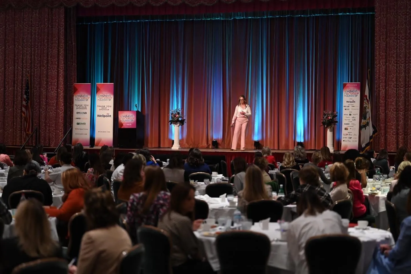 Joelle Moray leading a full audience from the stage