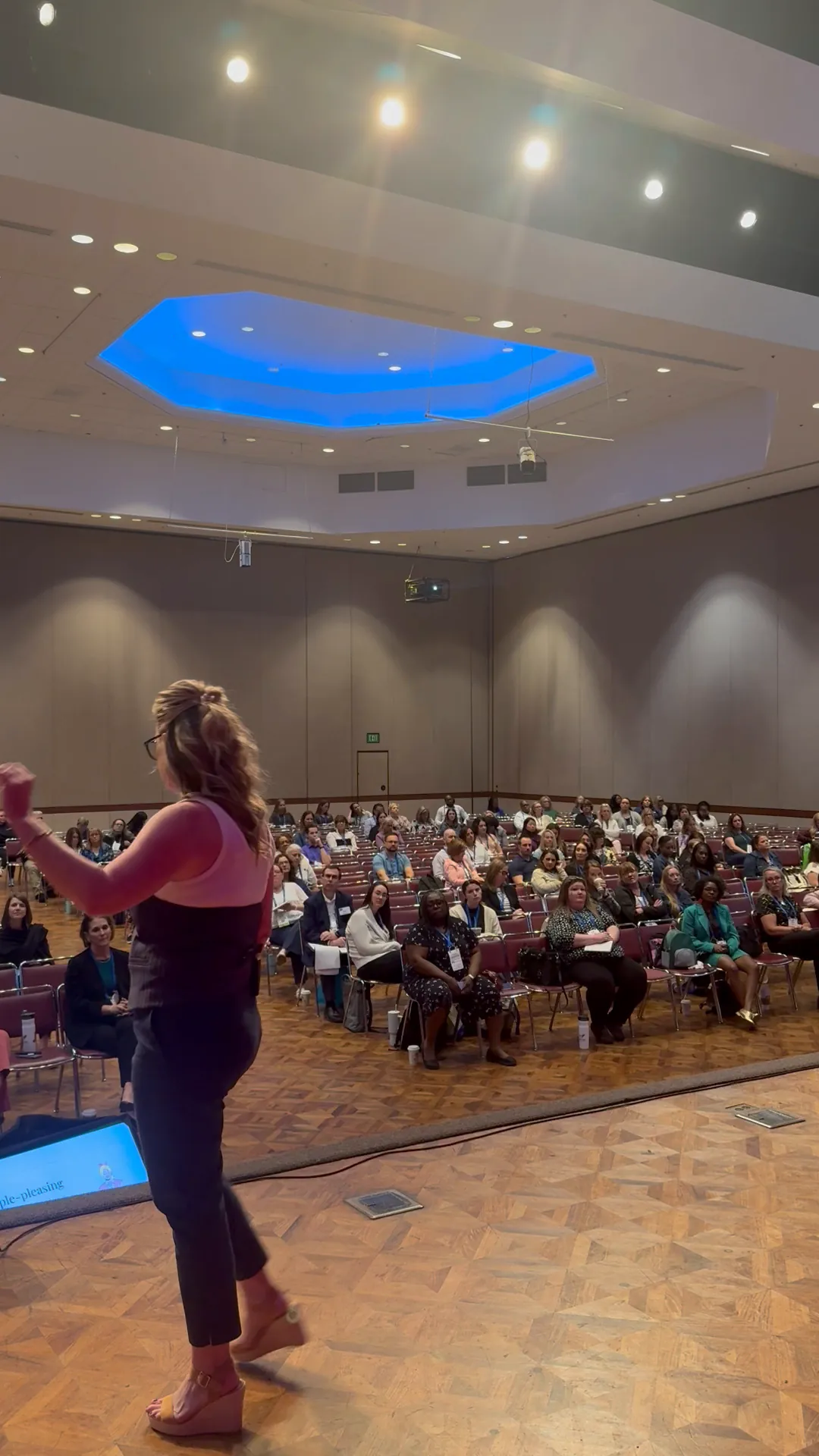 Joelle Moray on stage facing a full audience