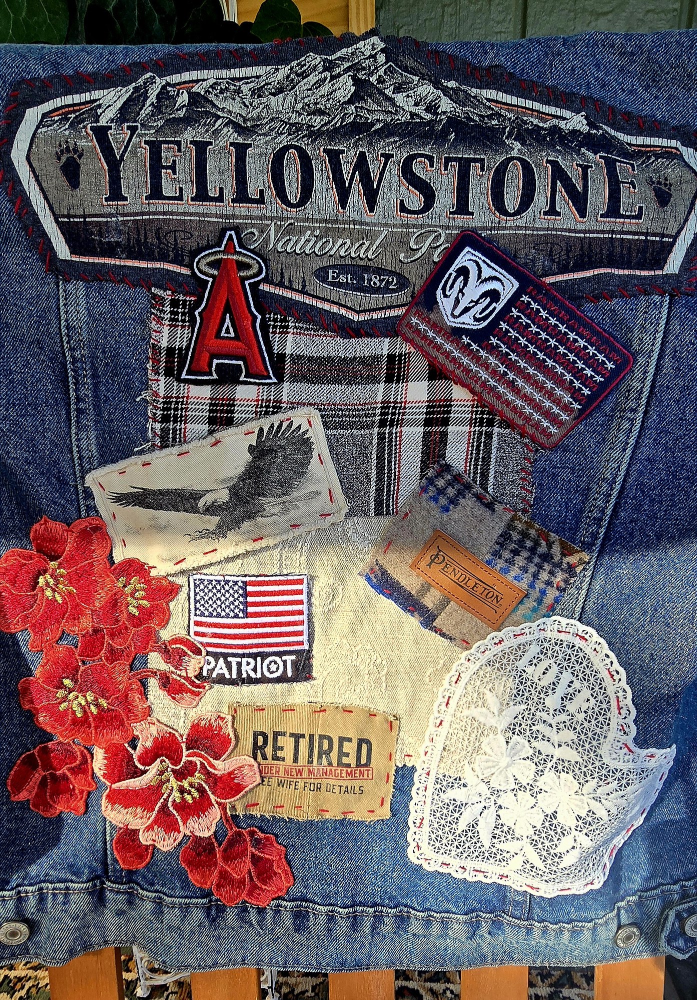 A finished blue denim Memory Jacket with Yellowstone, eagle, wildflower, and retirement patches