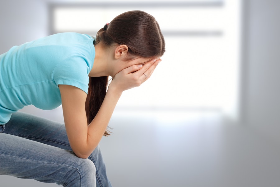 Woman sitting with her face in her hands