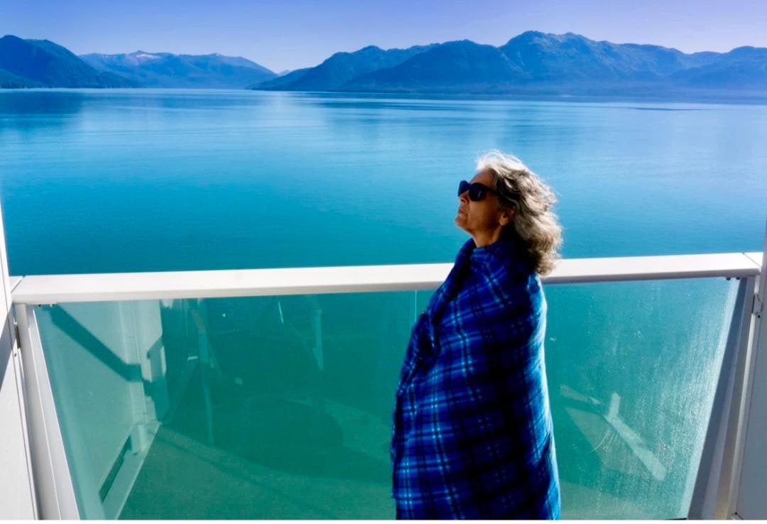 Christine overlooking a calm blue mountain lake