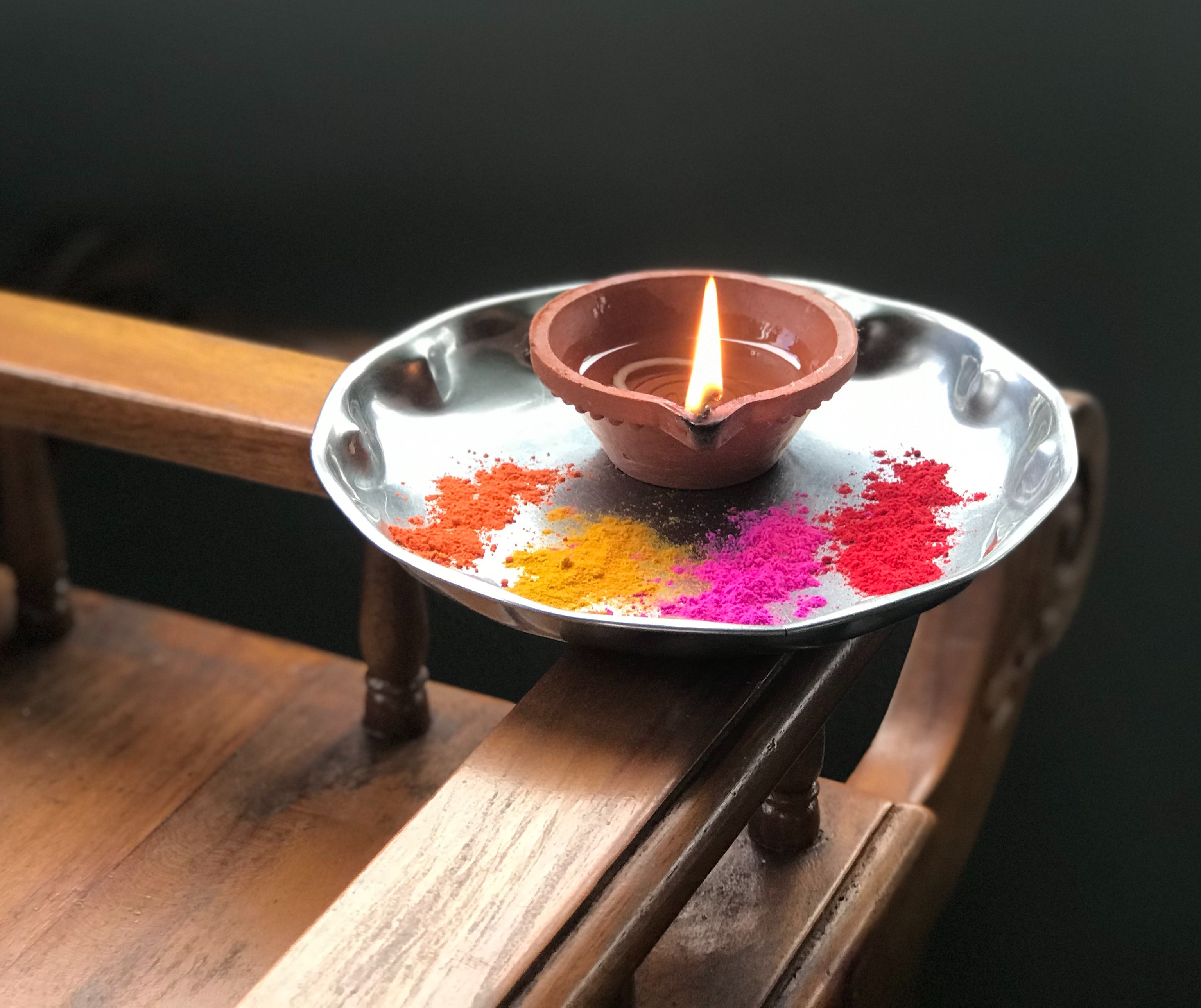 A lit candle surrounded by colorful powder