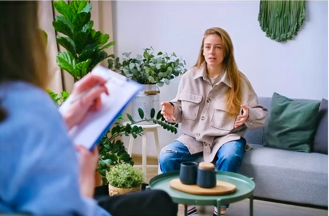 A woman speaking with a counselor in a welcoming room