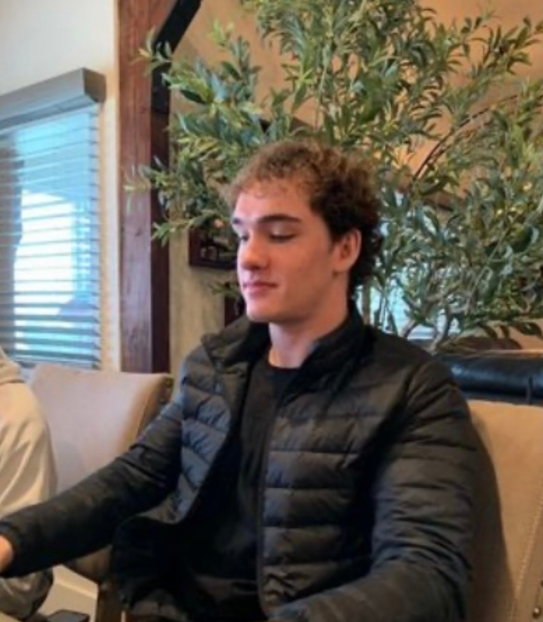 A young man sitting peacefully with his eyes closed
