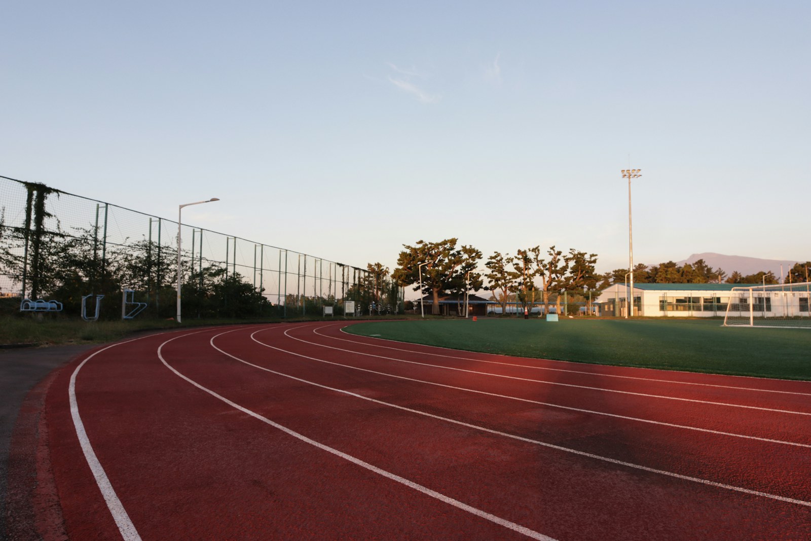 Empty red running track in early morning light