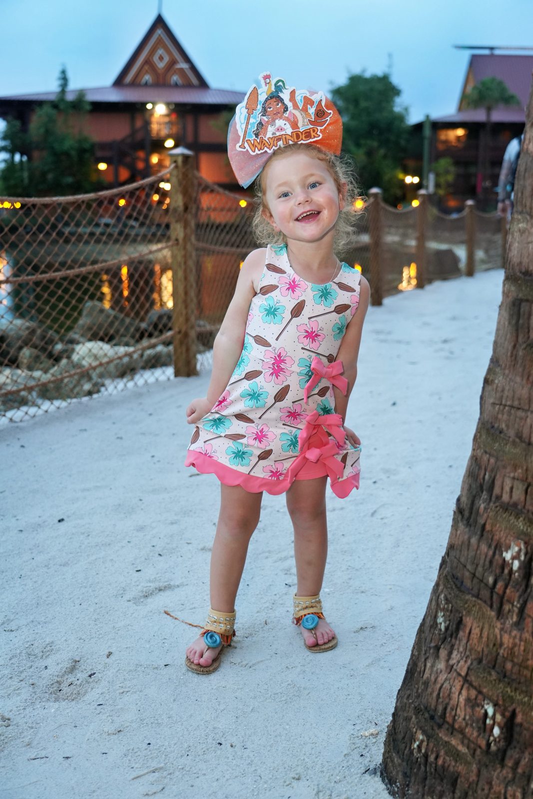 Londyn wearing a pink and turquoise printed dress and a colorful bow
