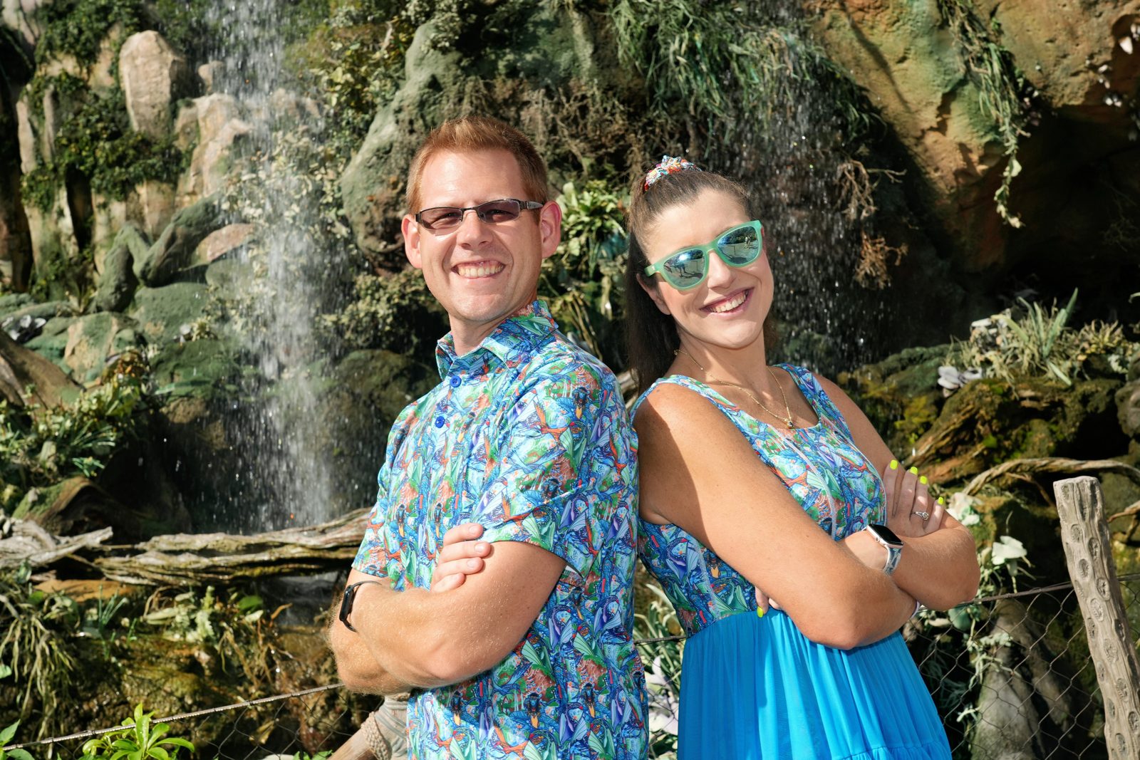 Brieanna and her partner wearing coordinating blue prints beside a waterfall