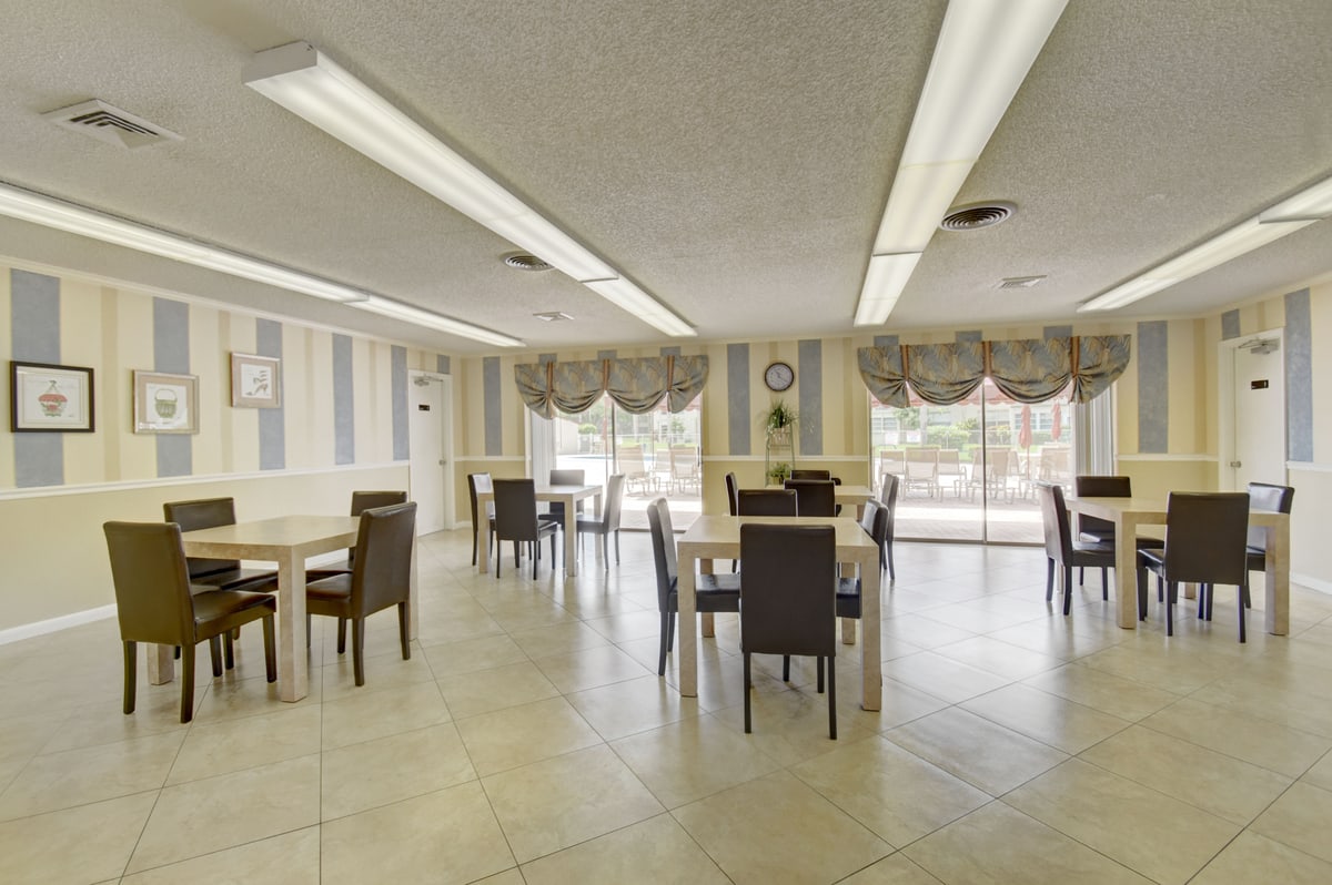 Abbey Village clubhouse gathering room with tables and windows