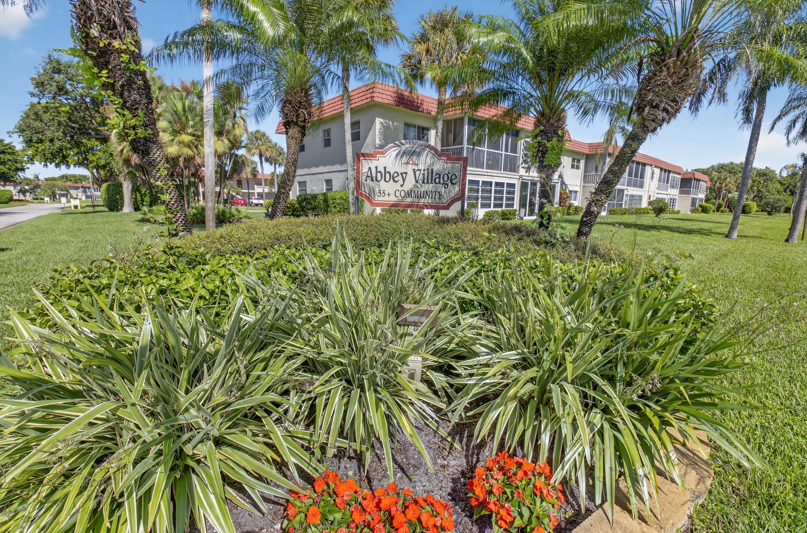 Abbey Village entrance sign surrounded by palms in Delray Beach