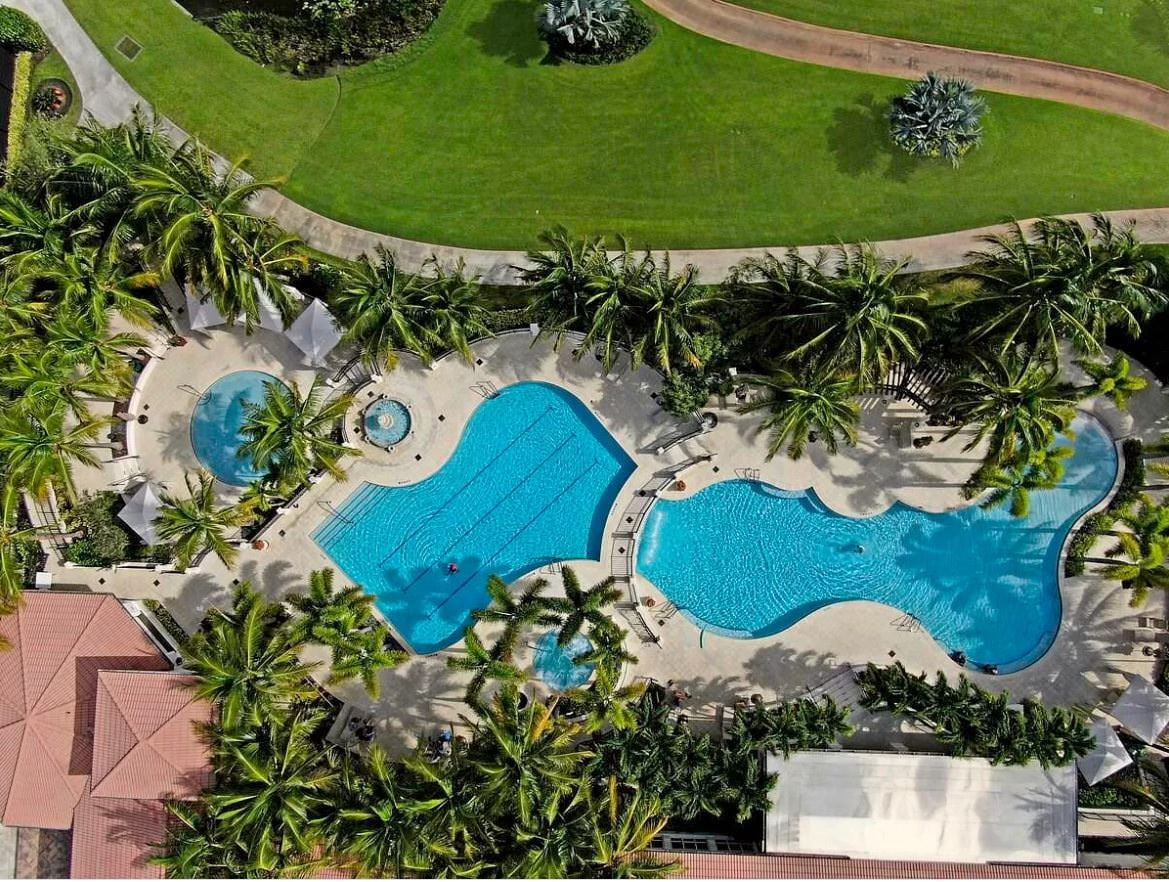 Aerial view of Aberdeen Country Club pools and palm-lined deck