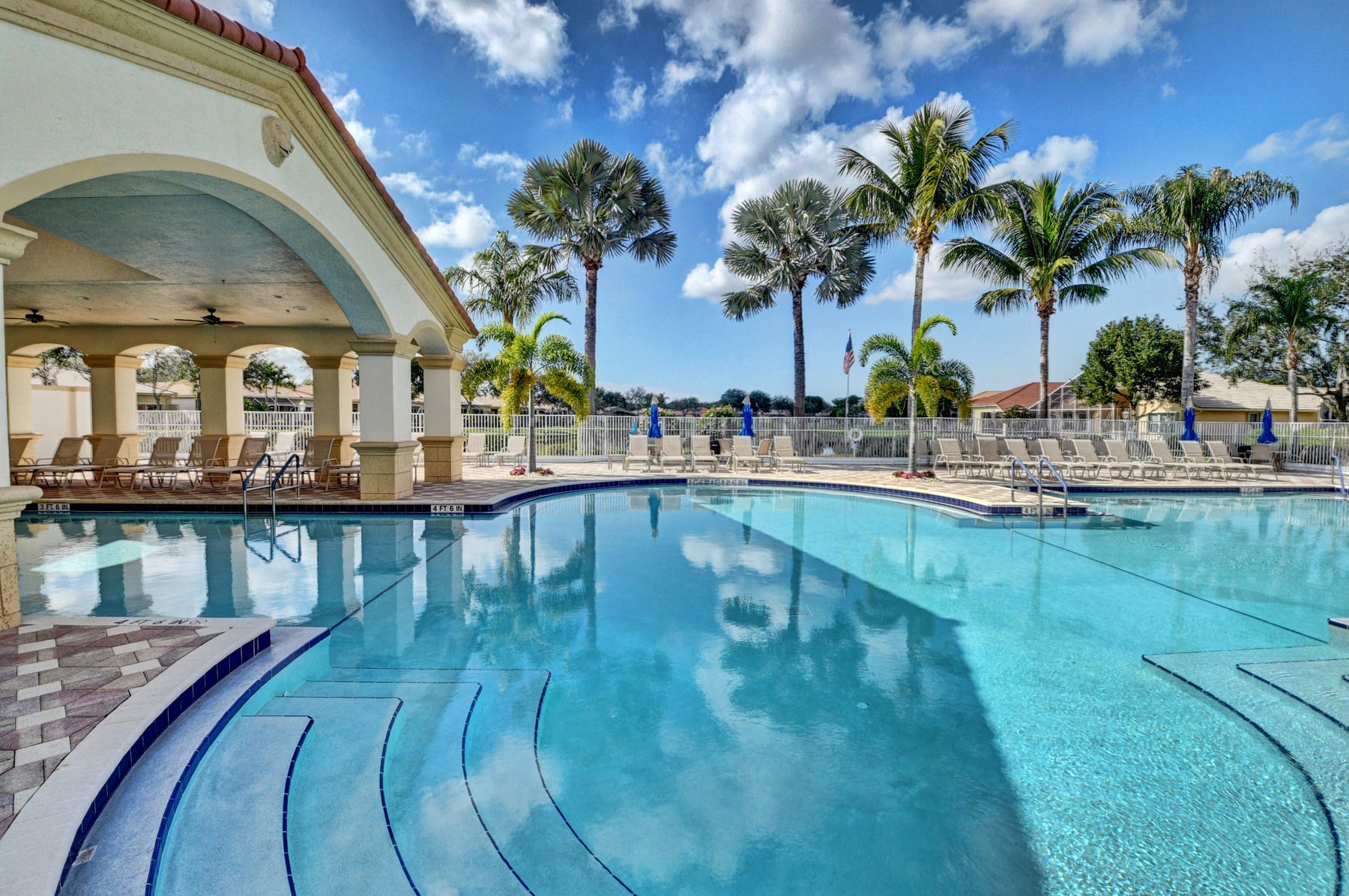 Outdoor swimming pool with lounge chairs and palms at Avalon Estates
