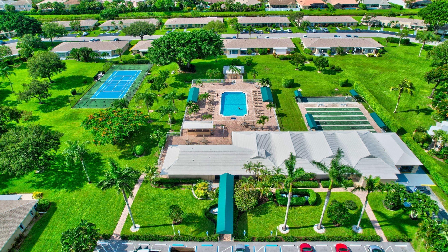 Aerial view of Boca Lakes clubhouse, pool, tennis court, and shuffleboard courts