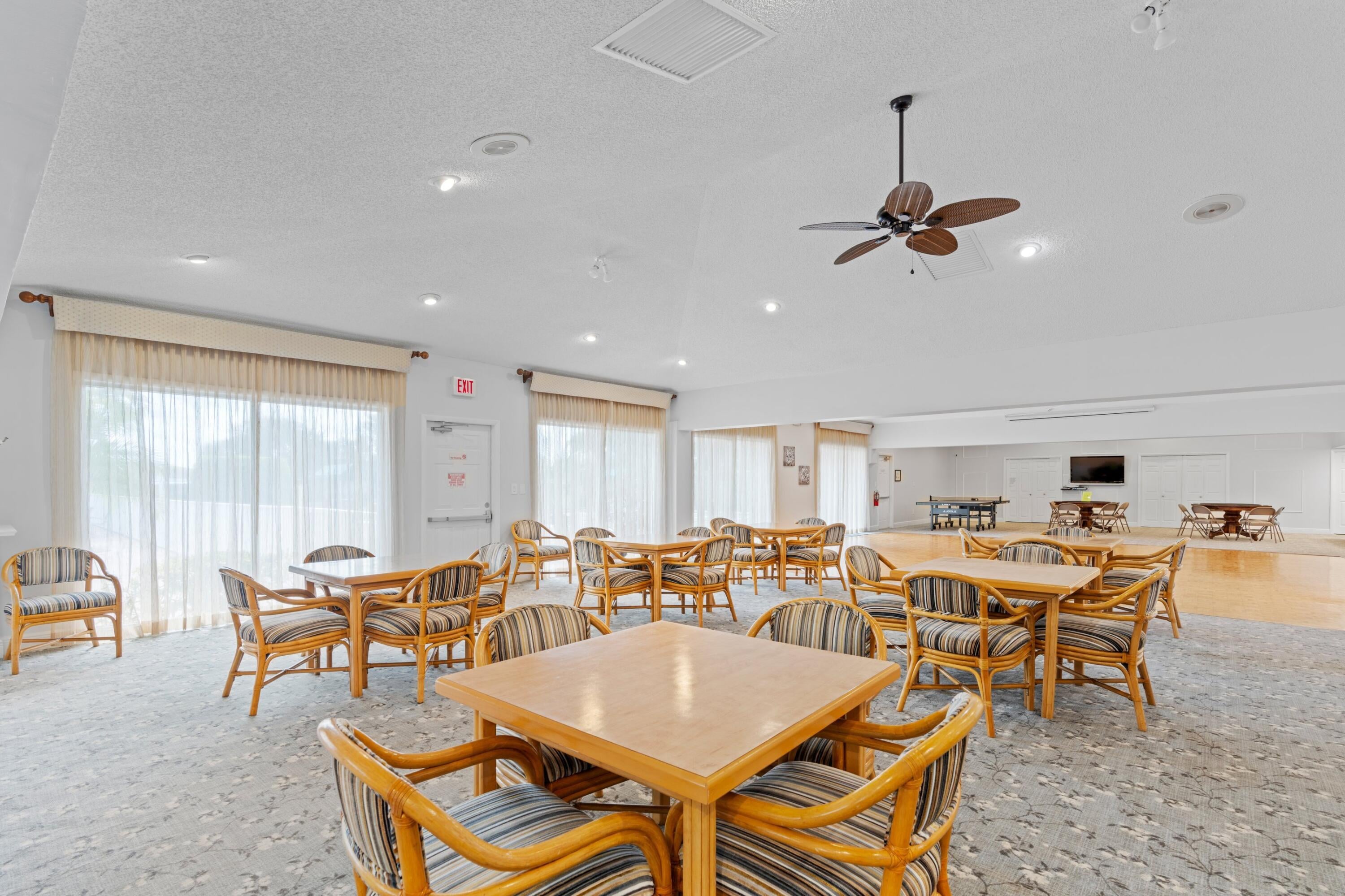 Boca Lakes clubhouse gathering room with tables and seating