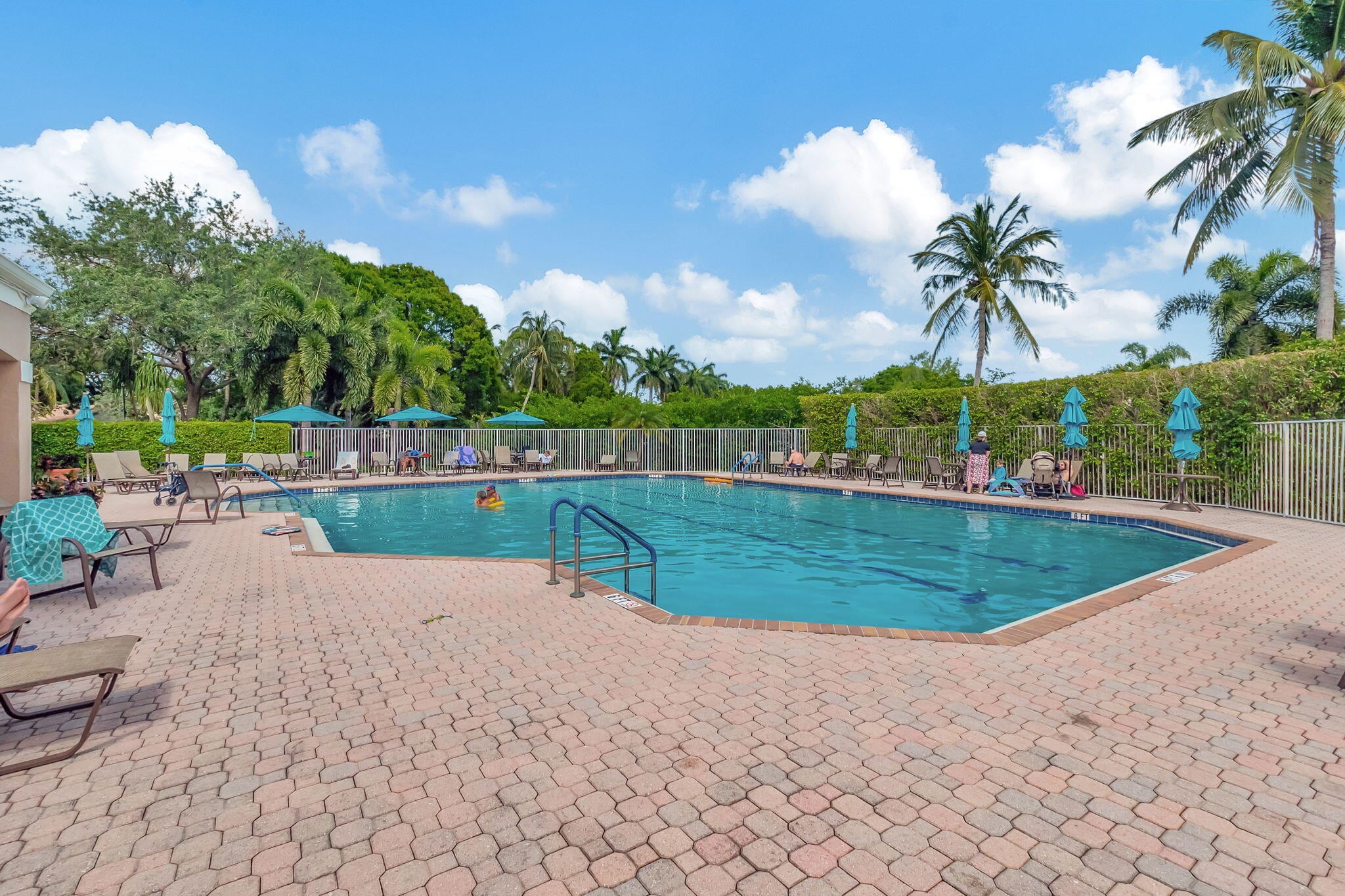 Outdoor pool with palm trees at The Club at Indian Lakes