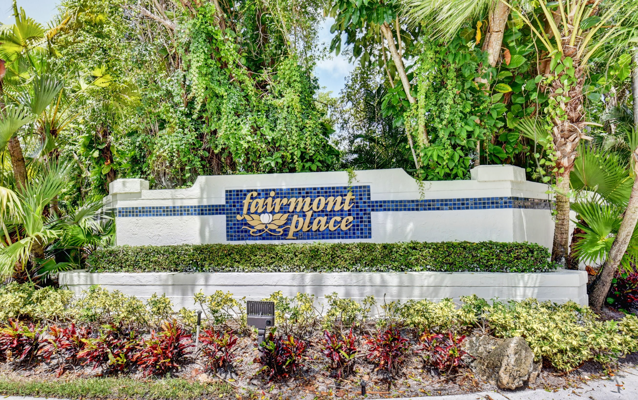 Landscaped Fairmont Place entrance sign in Boynton Beach