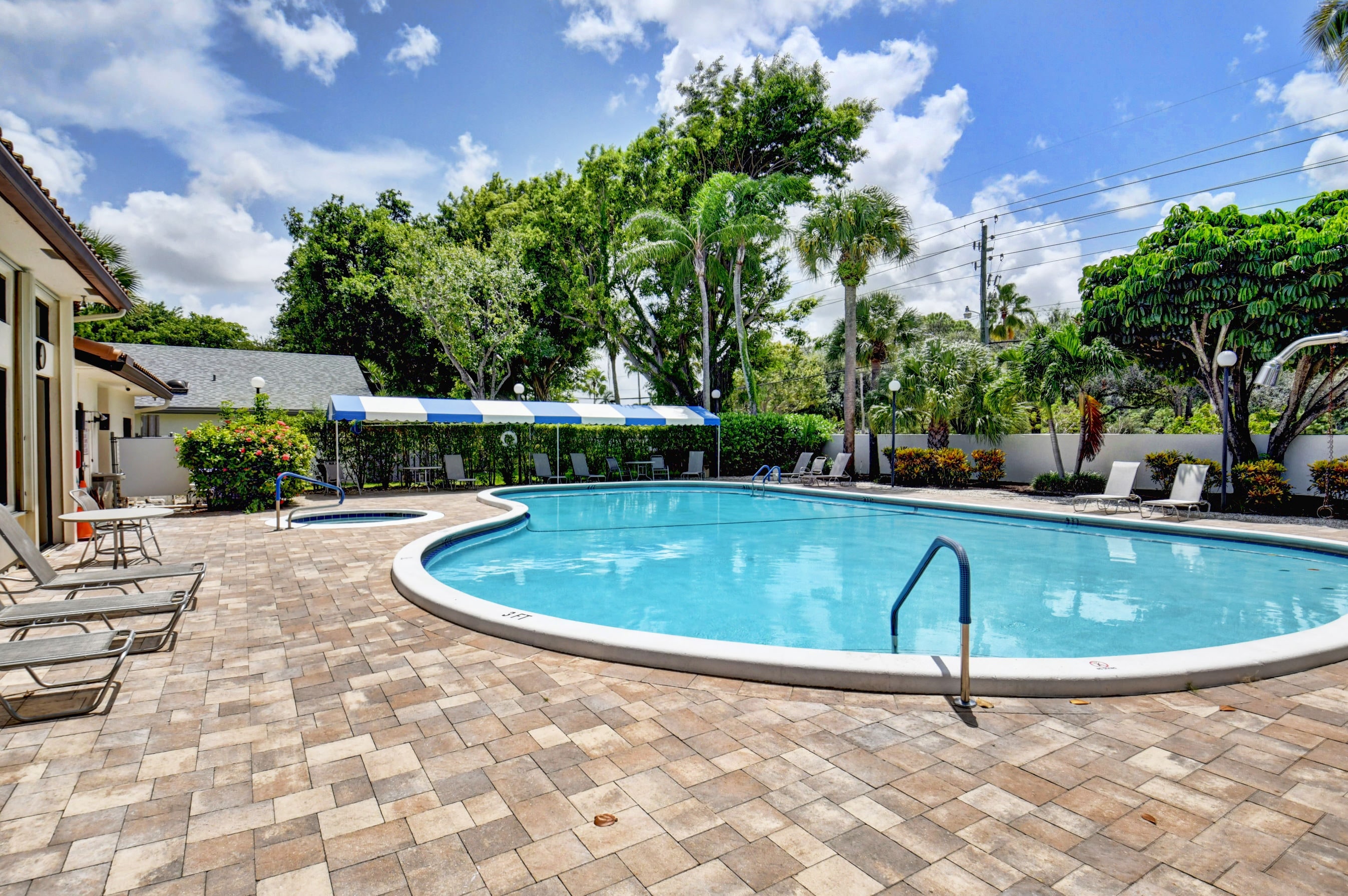 Fairmont Place outdoor community pool with shaded seating and palm trees