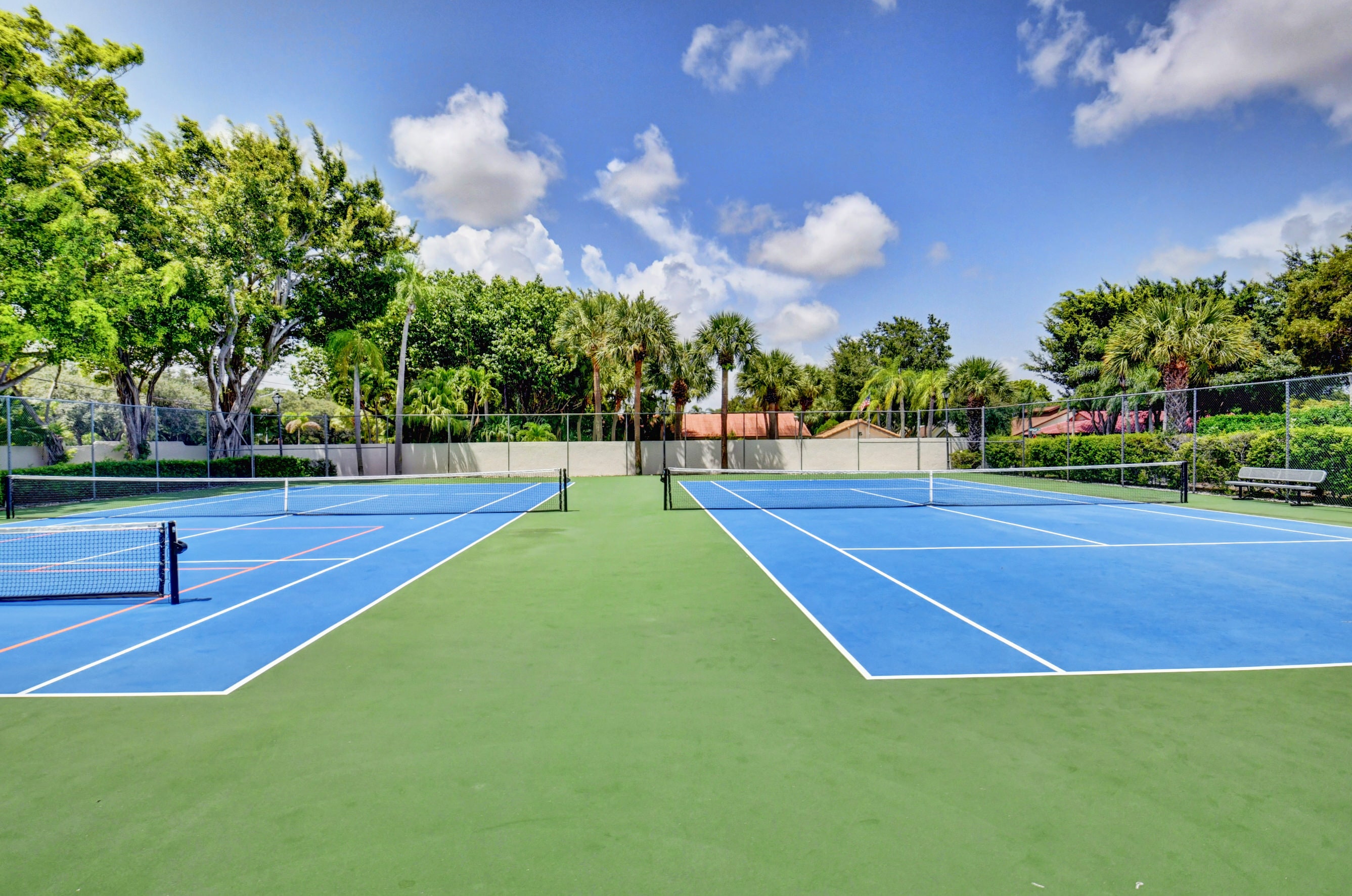 Fairmont Place tennis courts surrounded by mature landscaping