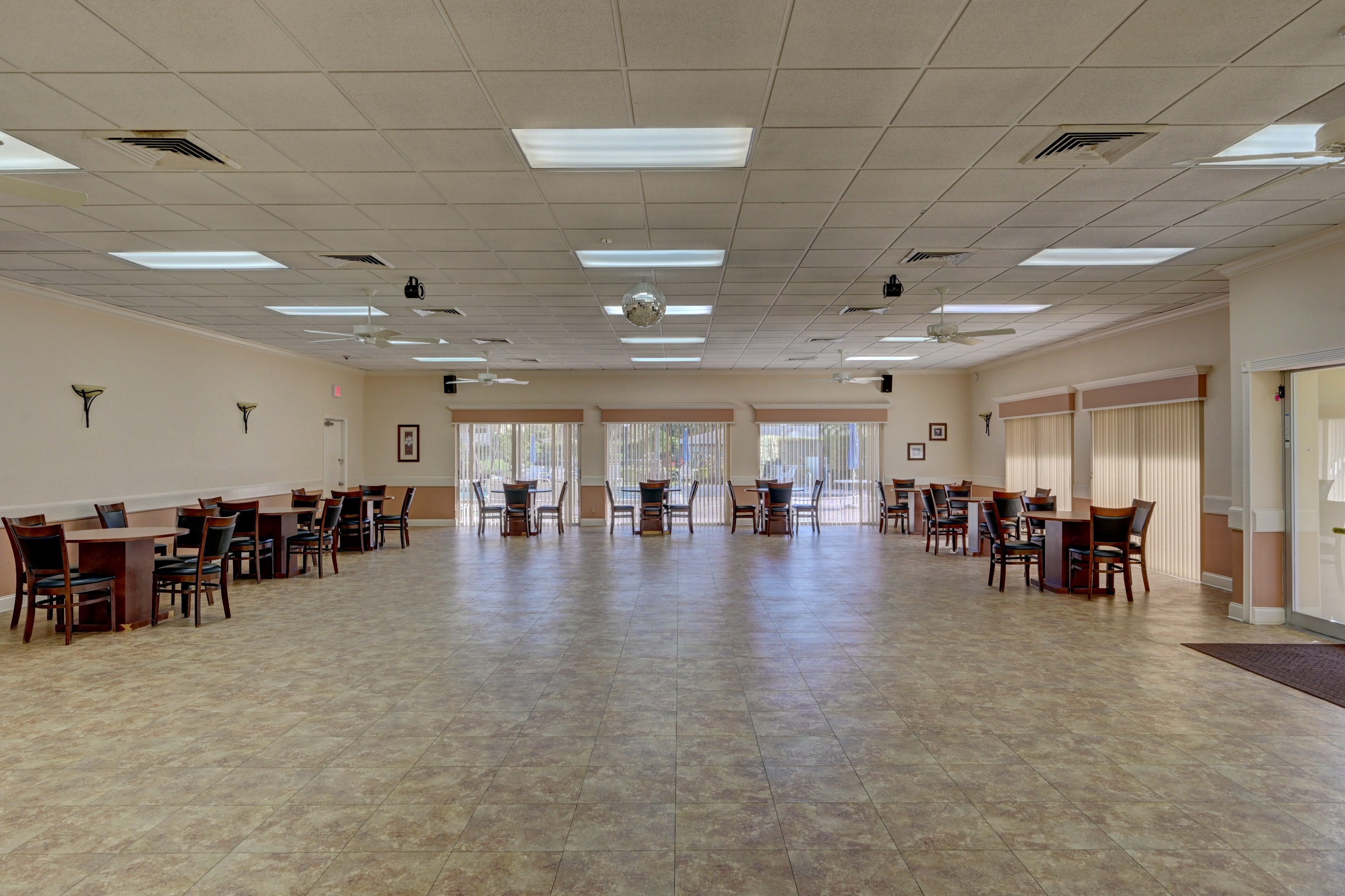 Pines of Delray clubhouse gathering room with dining tables and open floor space