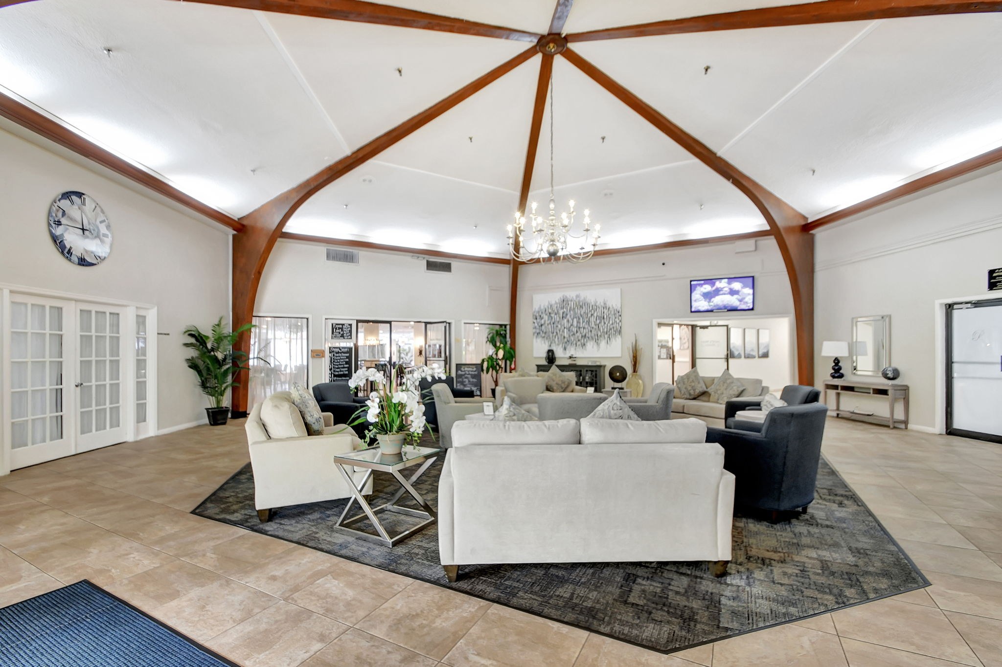 Poinciana clubhouse lounge with a vaulted wood-beam ceiling and seating area