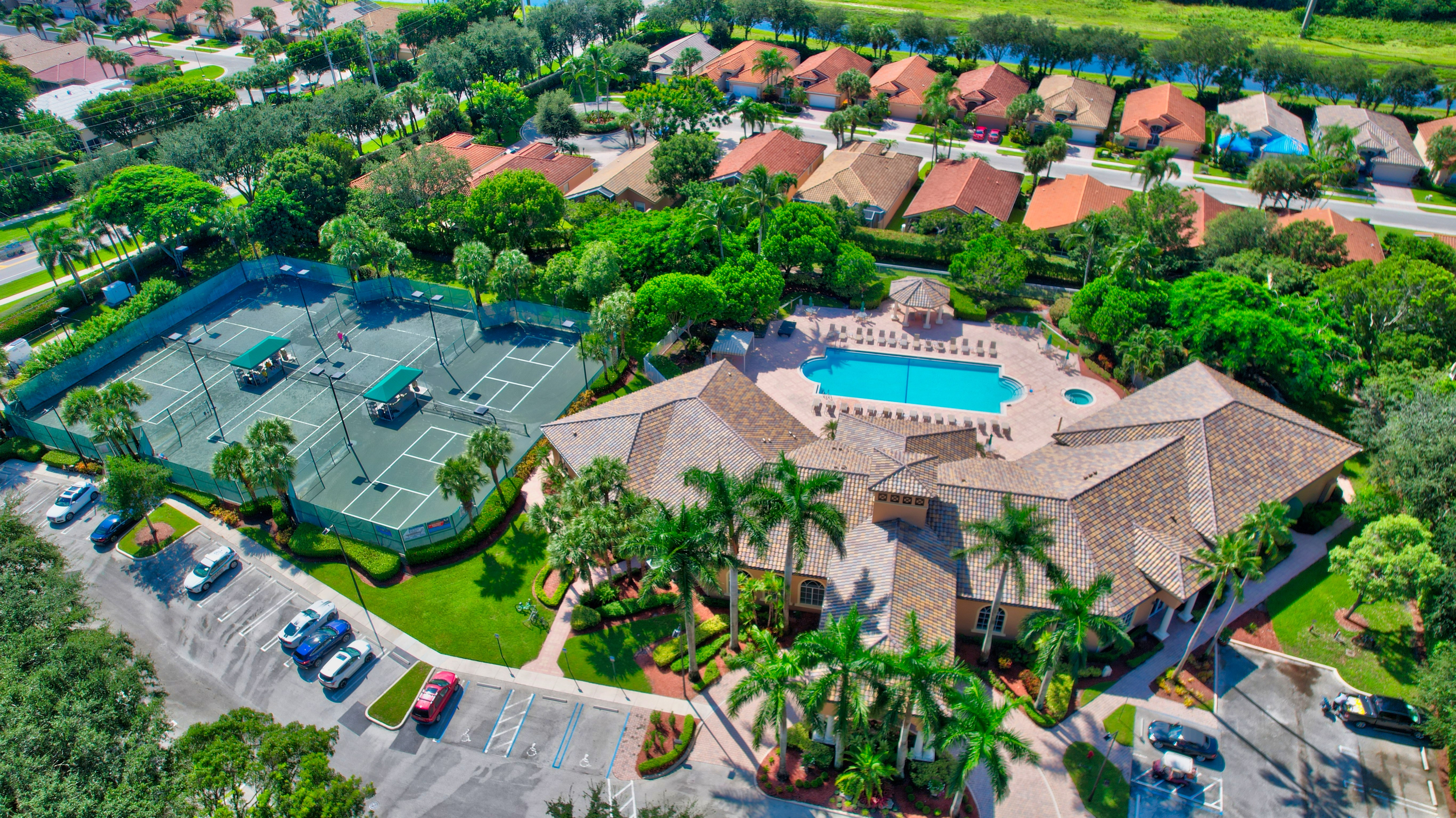 Aerial view of an active-adult clubhouse, pool, and recreation courts in Boynton Beach