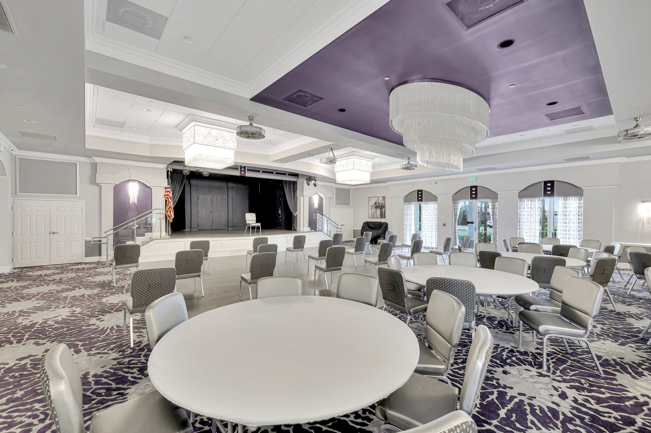 Majestic Isles clubhouse ballroom with wood dance floor, chandeliers, tables, and seating