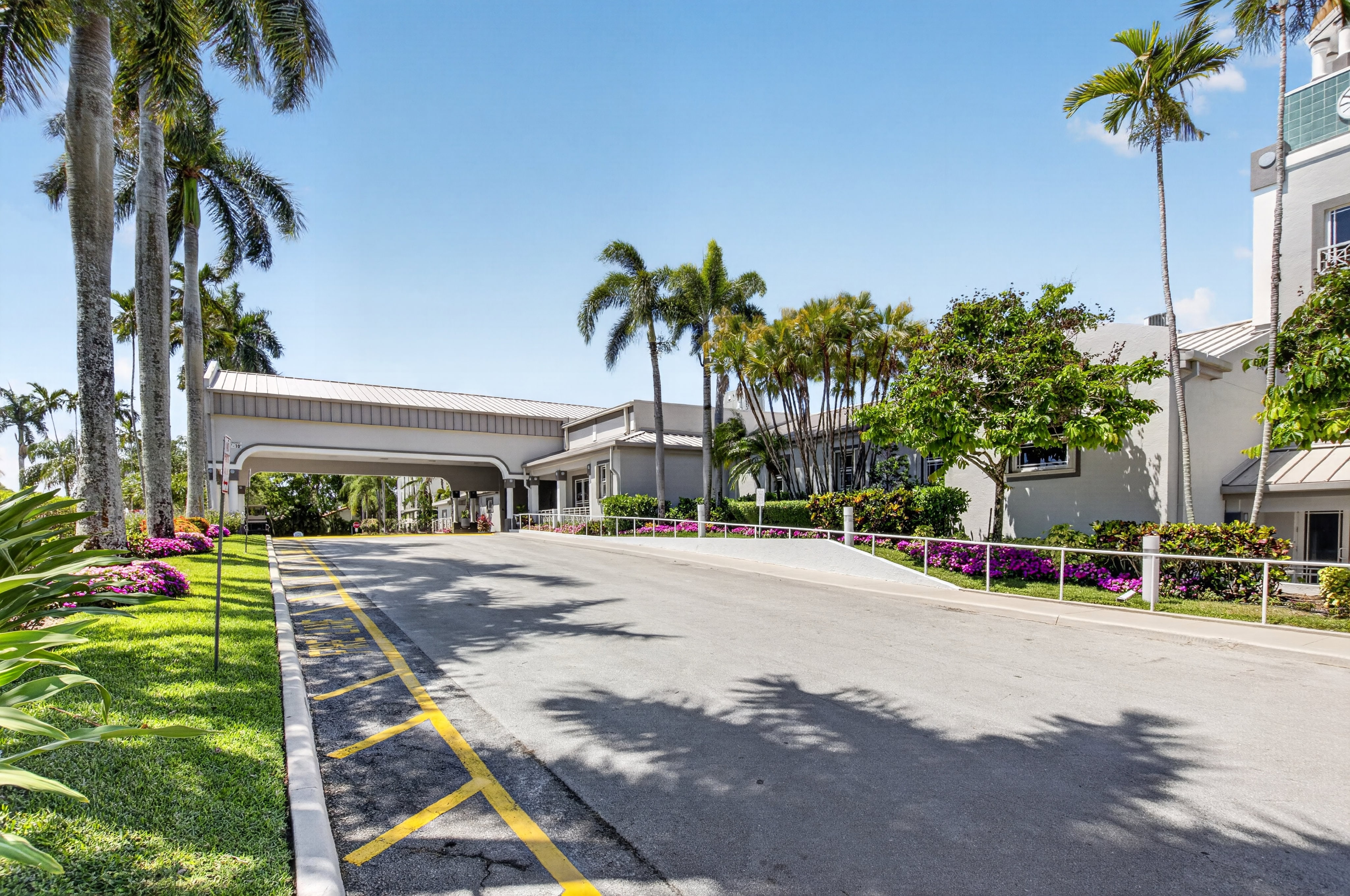 Palm Isles clubhouse entrance framed by palms and landscaped grounds