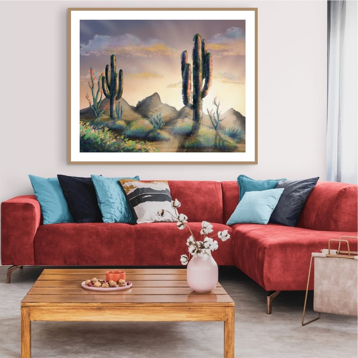 Landscape artwork above a red sectional sofa in a living room