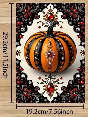 An ornate orange pumpkin with black flourishes and jewel-like details