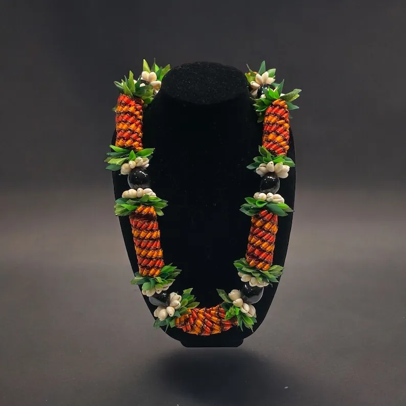 Handmade orange, red, and green ribbon lei with kukui nuts and shells