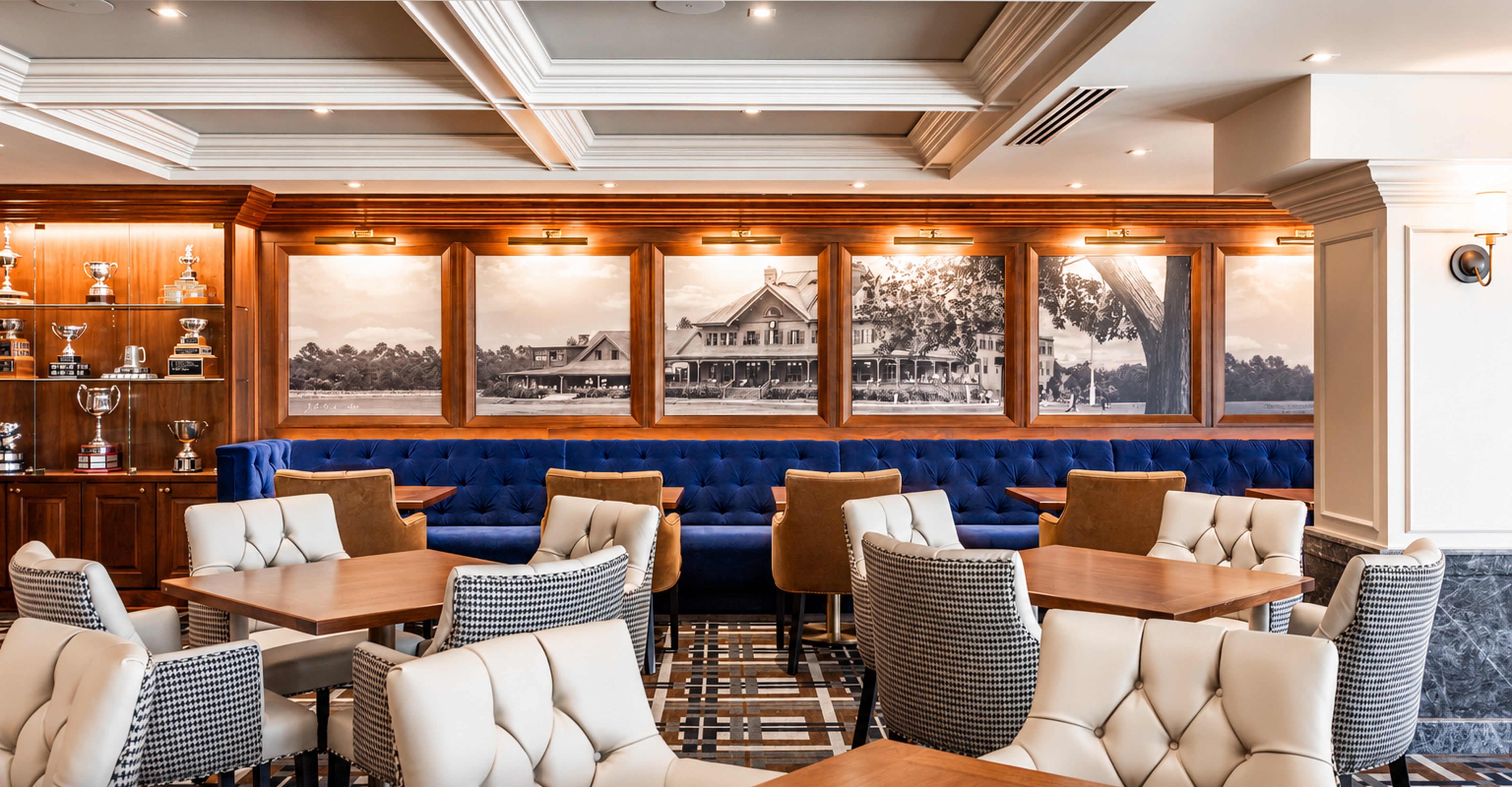 Warmly lit golf club dining room with blue banquette seating and wood details