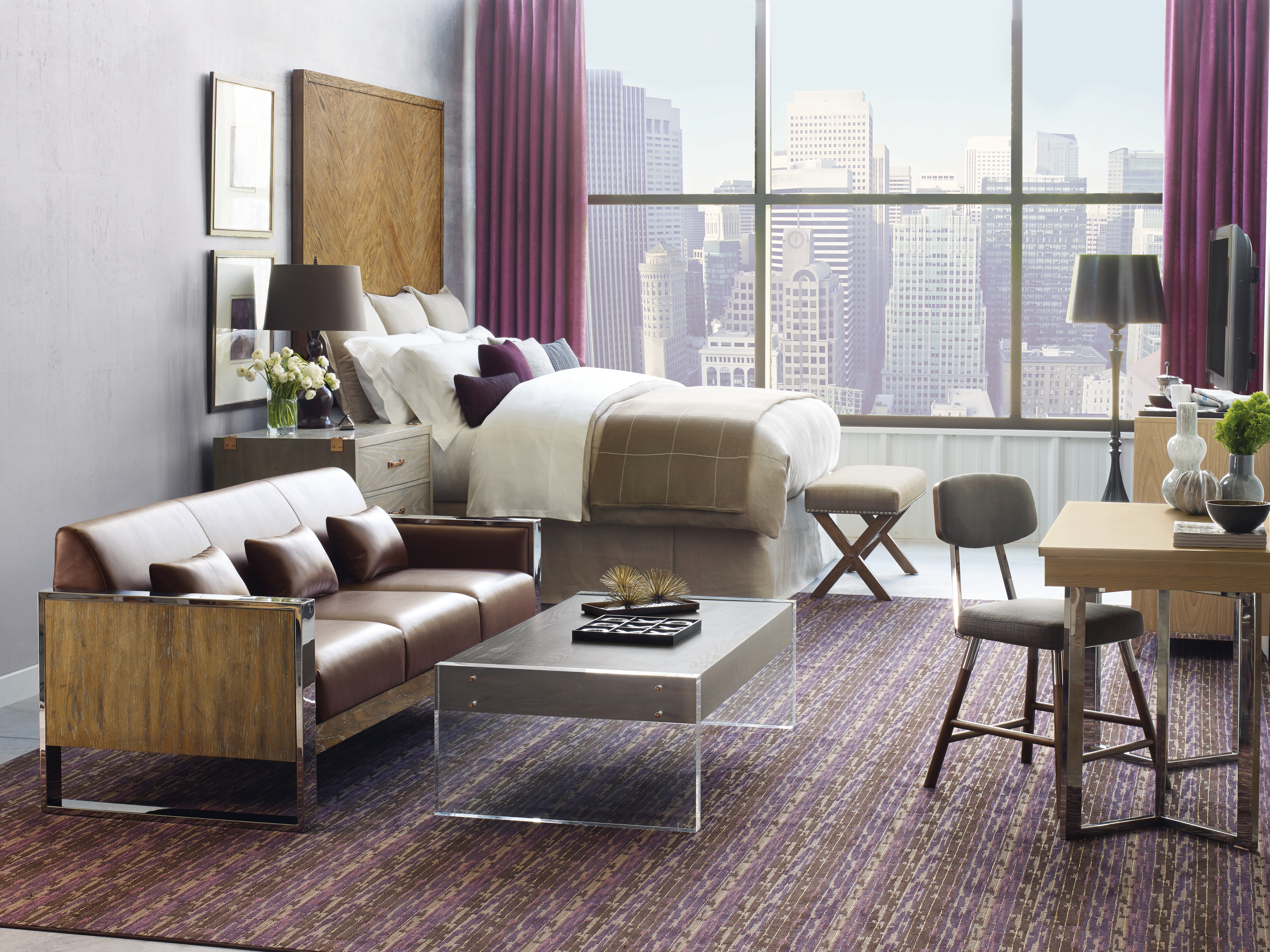Upscale hotel guest room with lounge seating, work table and city view