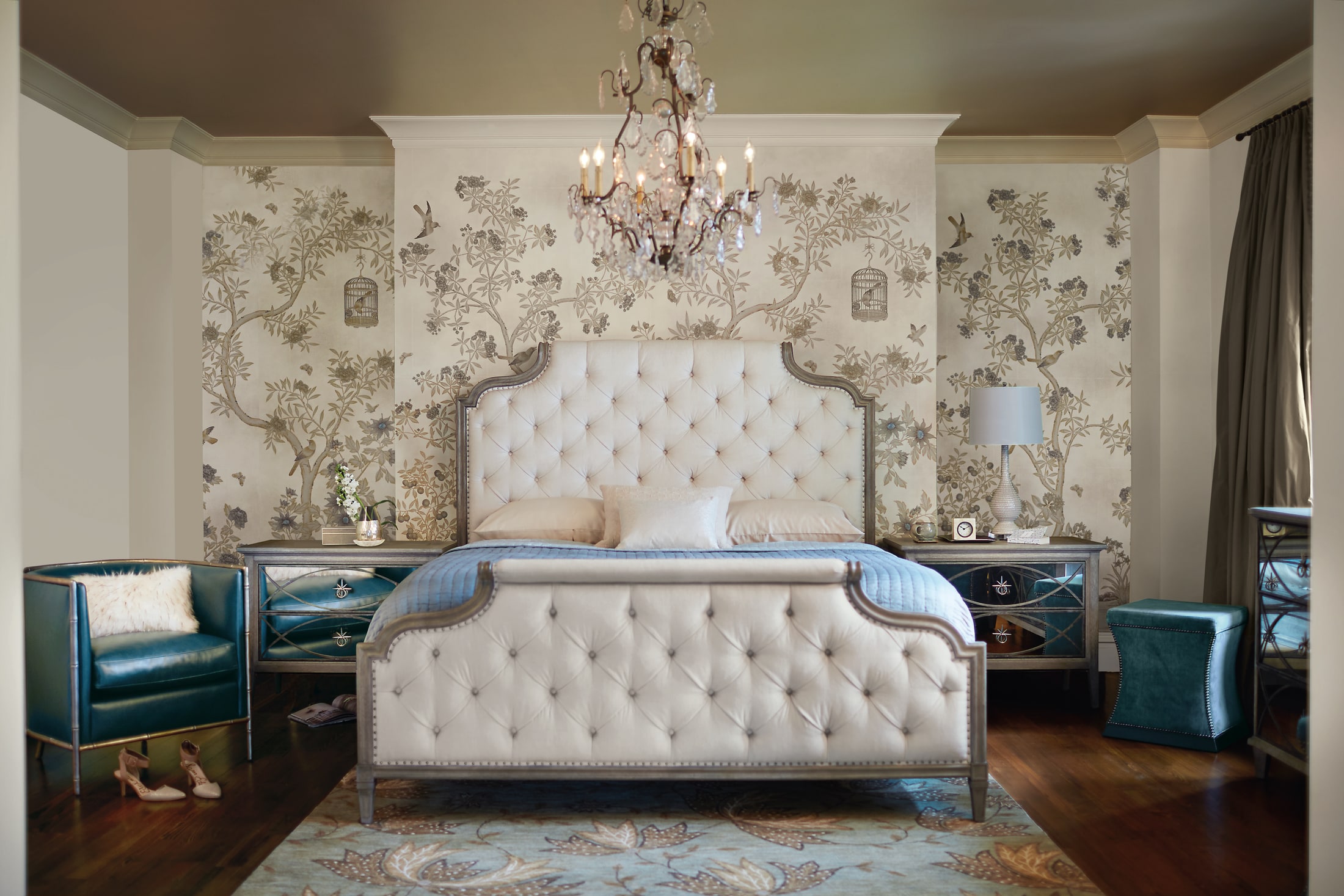 Marquesa bedroom with an upholstered bed, chandelier and patterned wallcovering