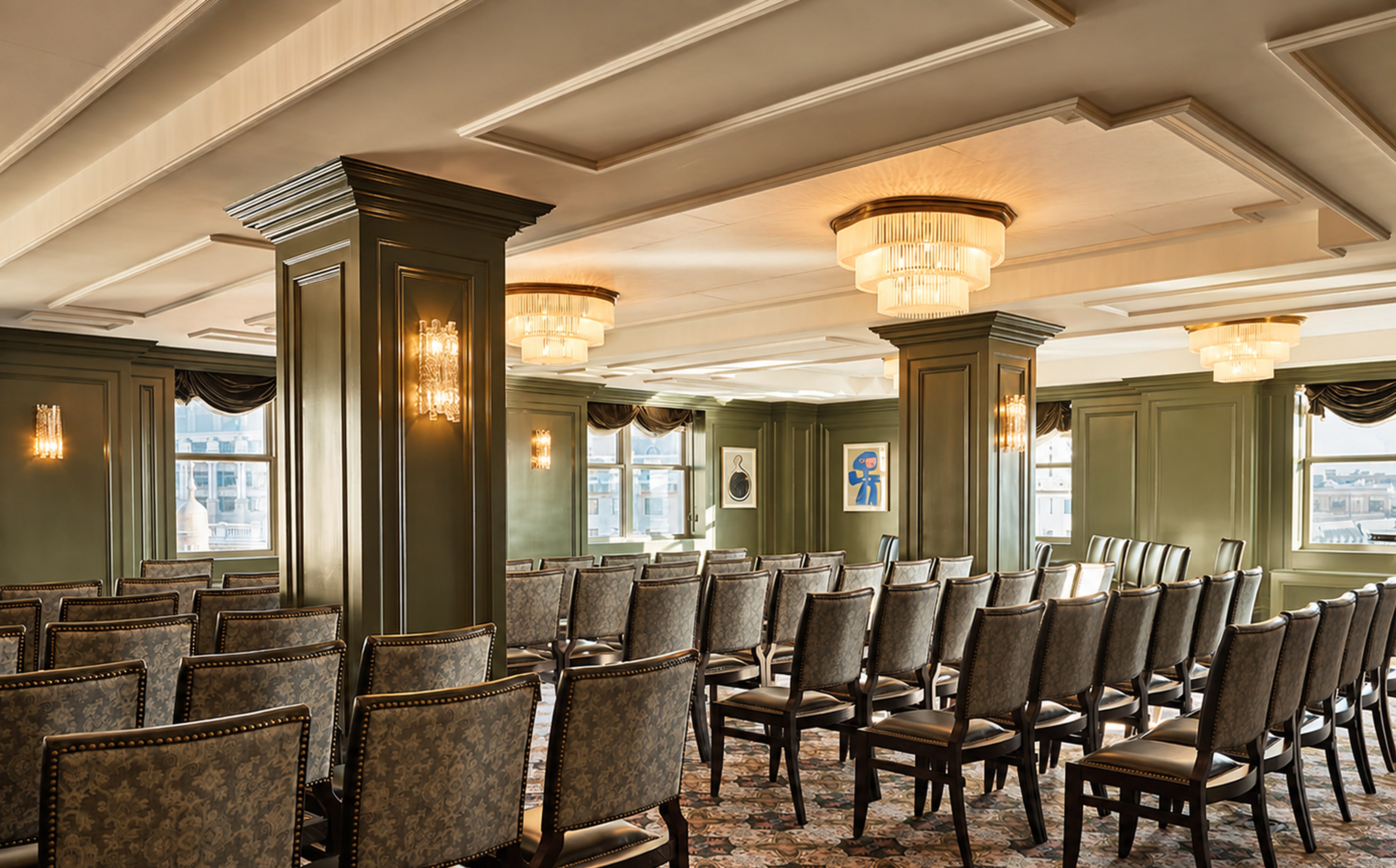 Warmly lit private dining room with rows of upholstered chairs