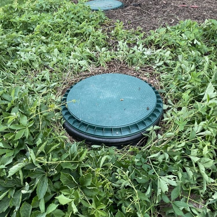 Technician inspecting an open septic tank